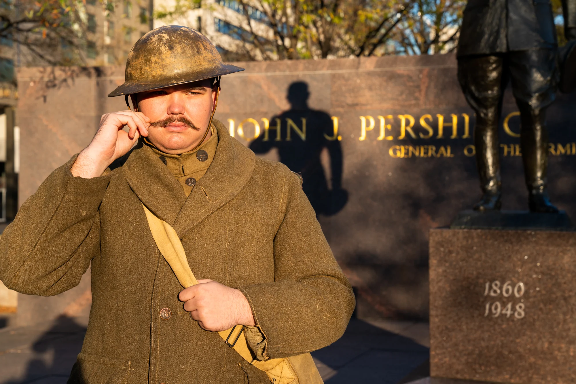 A World War I American troop re-enactor twirls his mustache in Pershing Park.