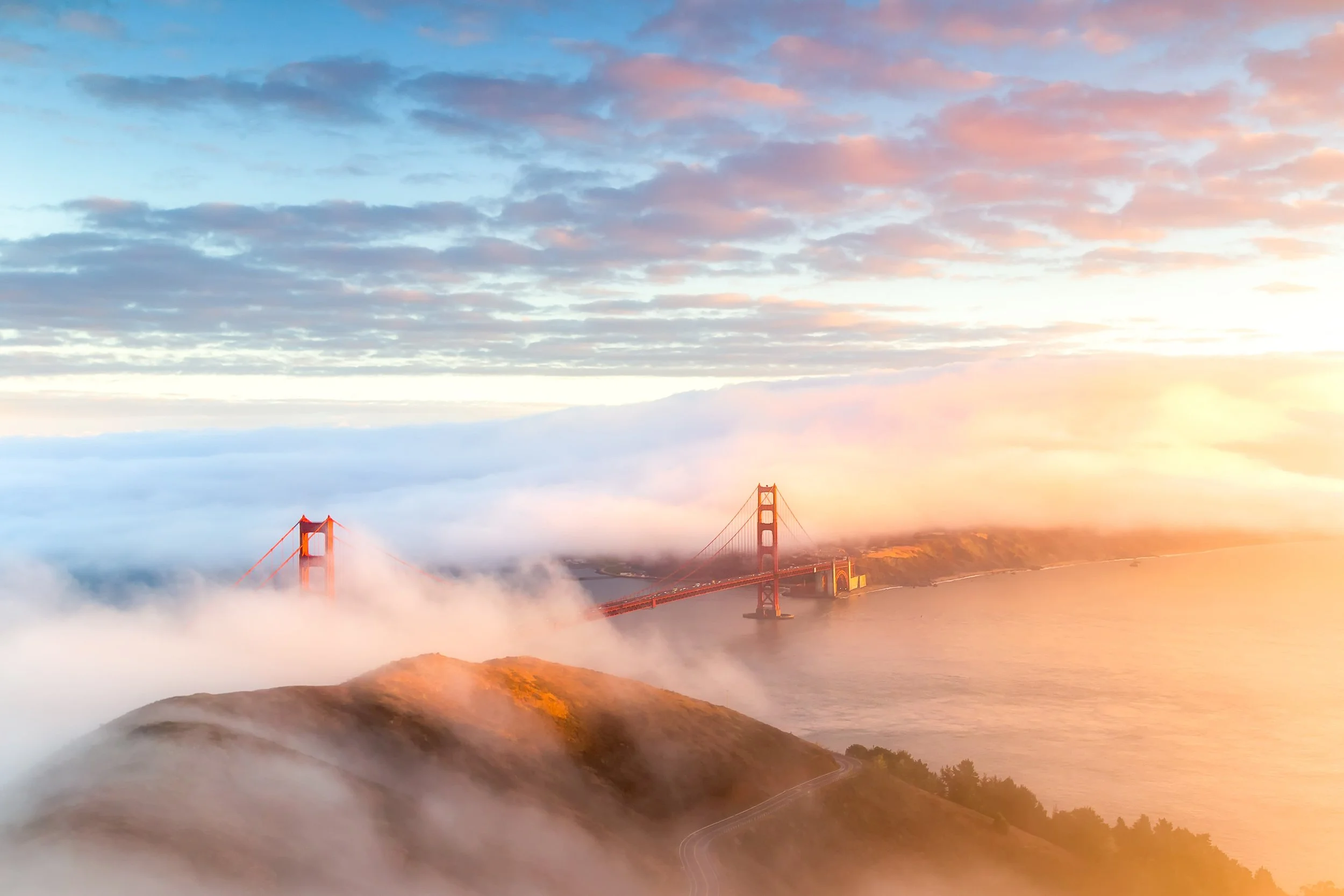 **Above the Fog**

Hawk Hill sits nearly 1,000 feet above sea level in the Marin Headlands—one of the few spots where you can photograph the Golden Gate Bridge from above.

On this evening, I climbed to the summit just as sunset light began illuminat