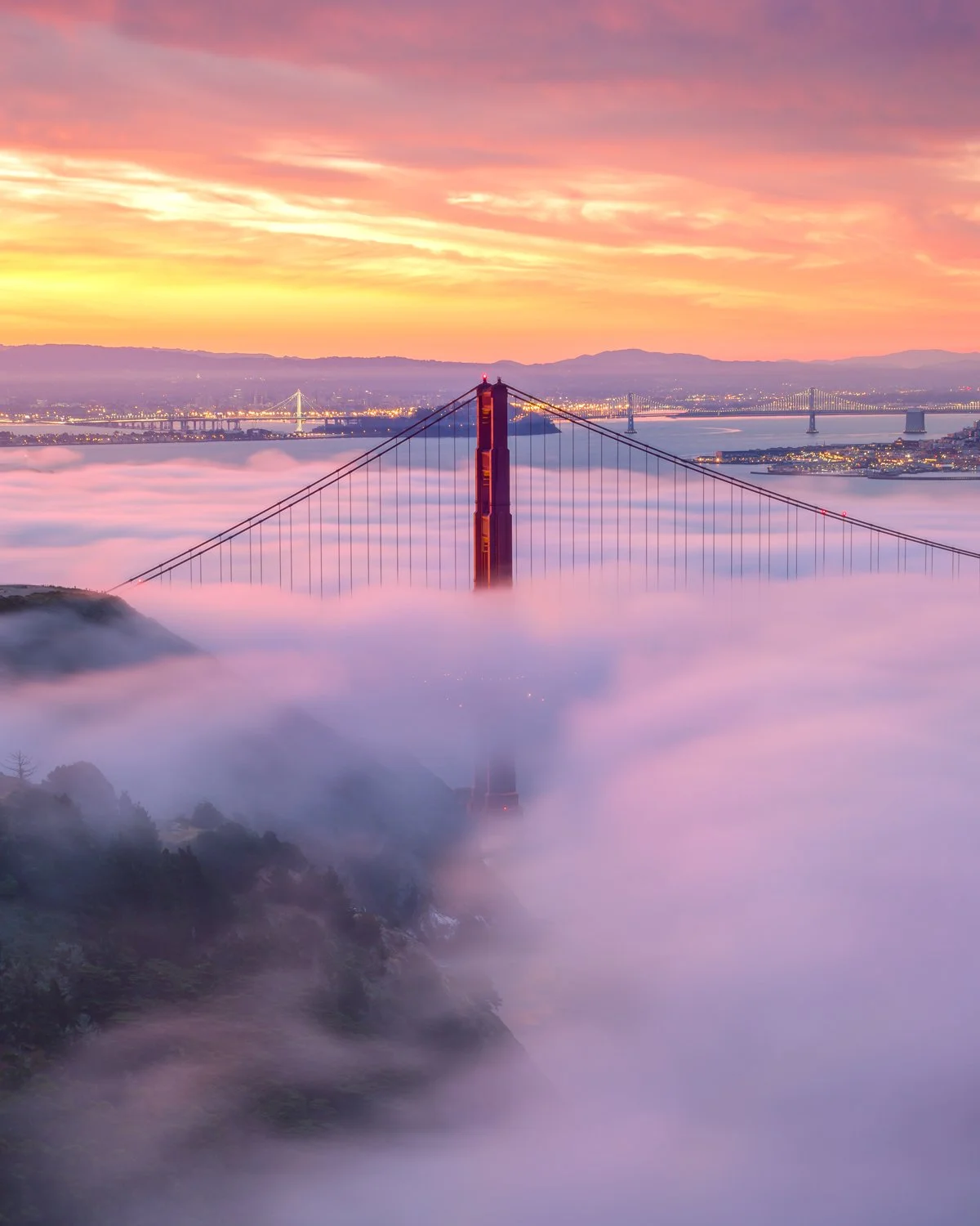 **Magenta Dawn**

The Golden Gate Bridge bathed in rare magenta light as sunrise illuminates fog-shrouded towers. Vertical orientation.

Some mornings, the light does something extraordinary. This wasn't the typical golden sunrise—the atmospheric con