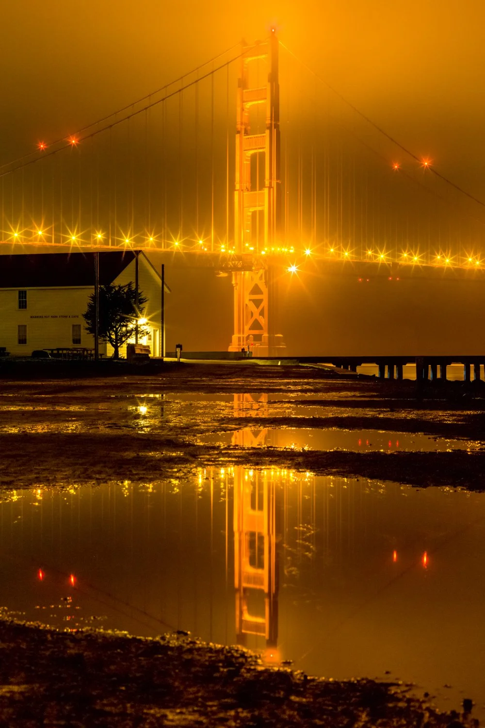 **After the Storm**

The Golden Gate Bridge reflected in a rain puddle after an evening storm—orange towers against dark, moody skies.

Most photographers pack up when the weather turns bad. I've learned that the best moments often come right after t