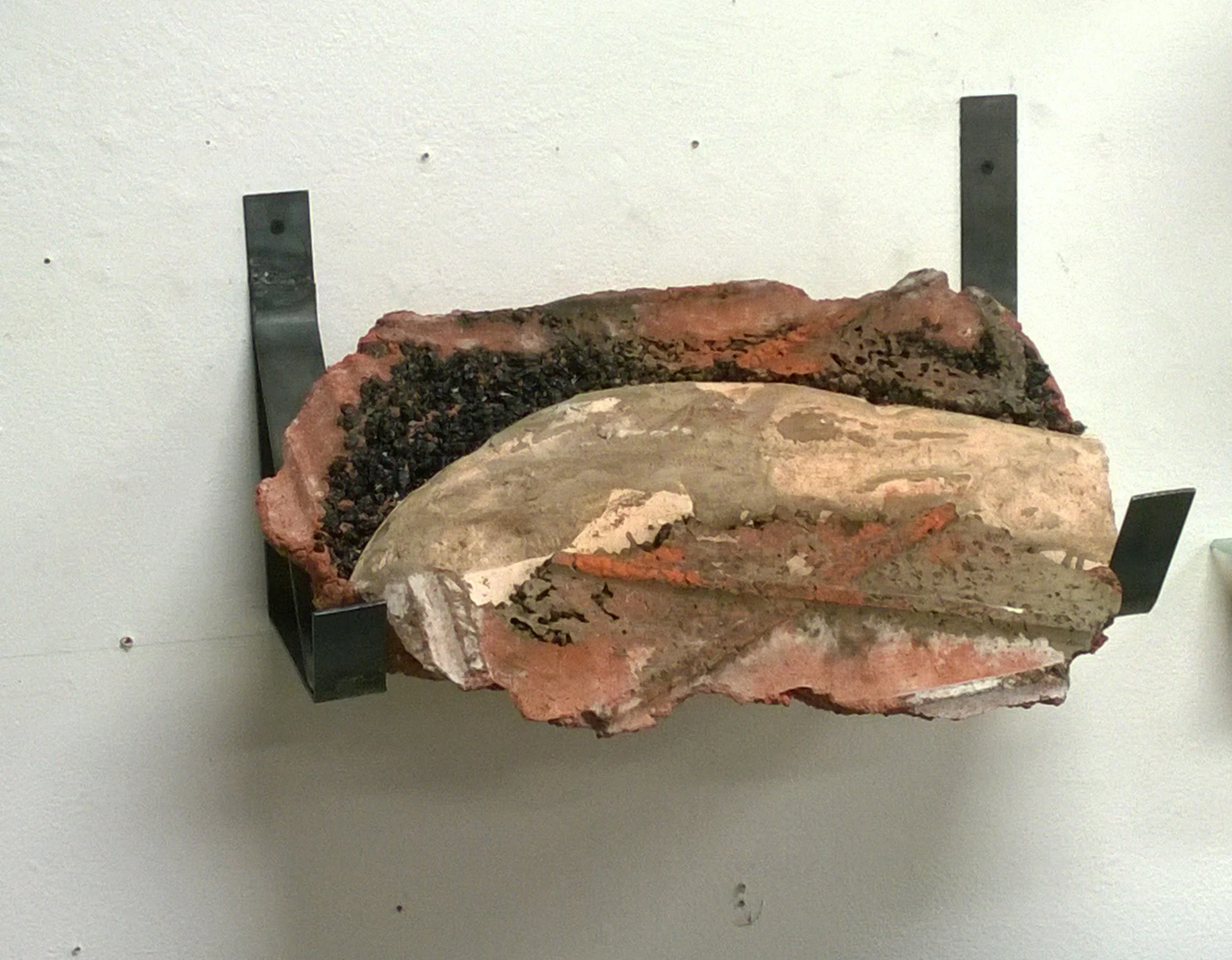 A large ice core sample mounted on a wall with metal supports.