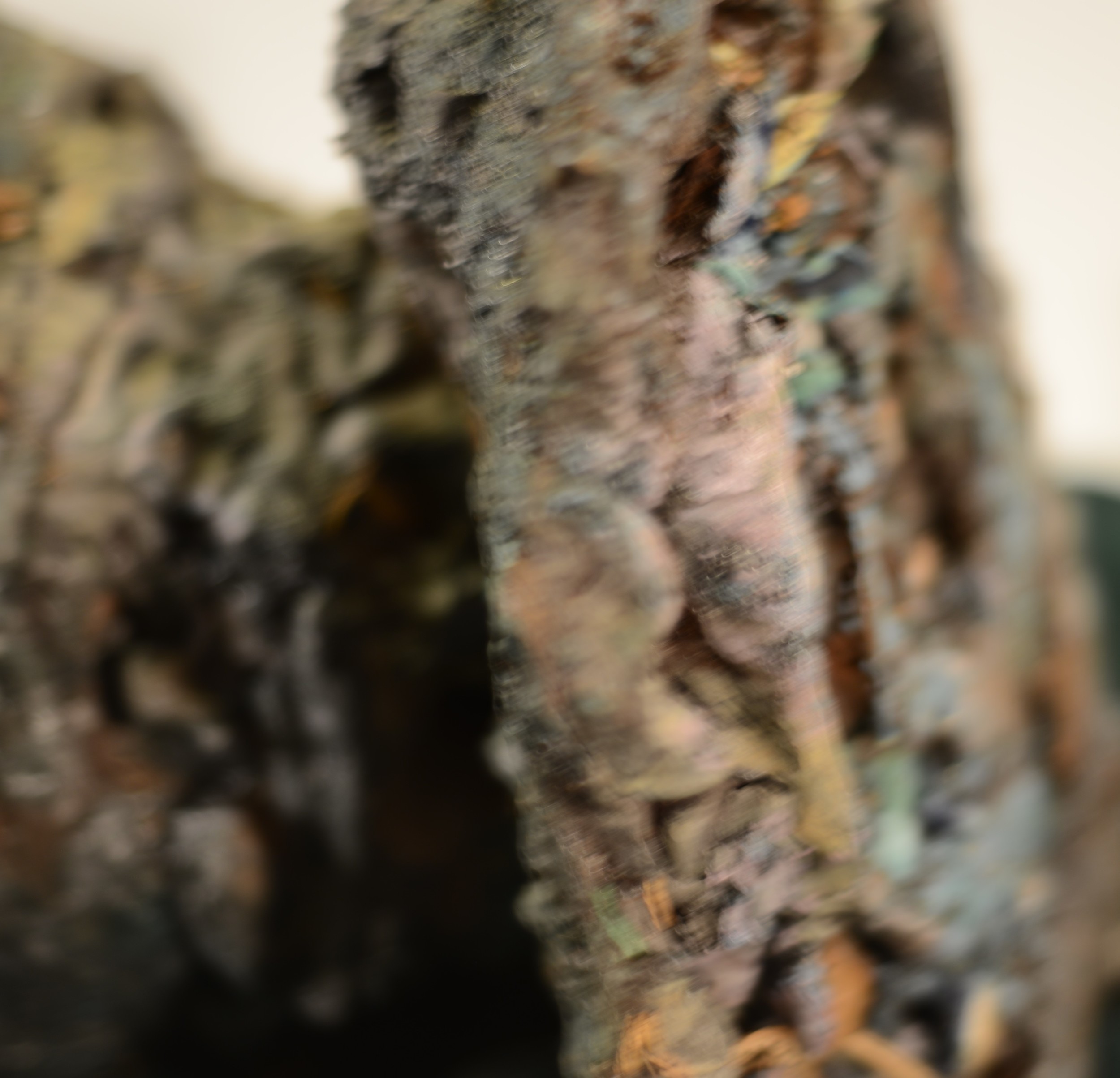 Close-up of a textured, roughly carved wooden sculpture.