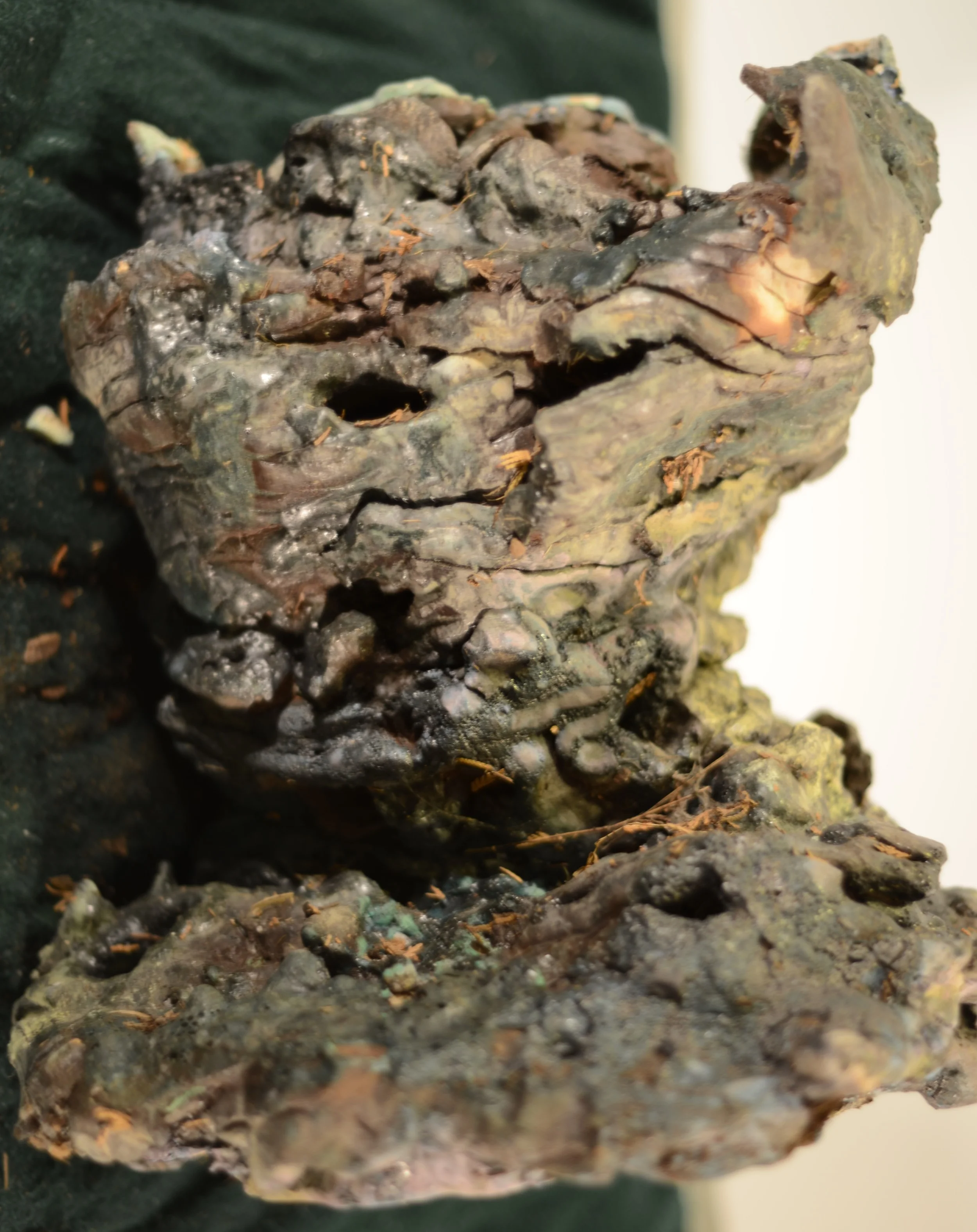 Close-up view of a large, irregularly shaped, dark-colored mineral or rock formation with a rough texture.