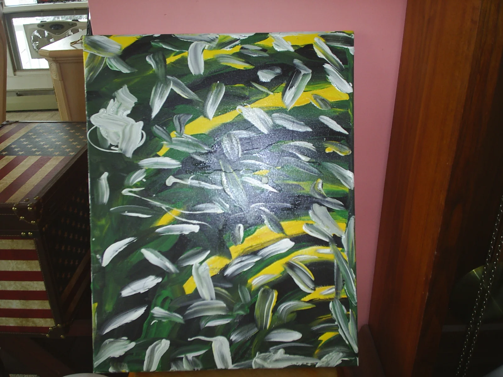 Abstract painting with green, white, and yellow brushstrokes on a large canvas.