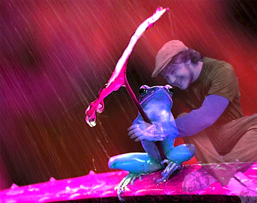 A person laughing and hugging a large, colorful frog puppet while sitting on the ground under a red tent.