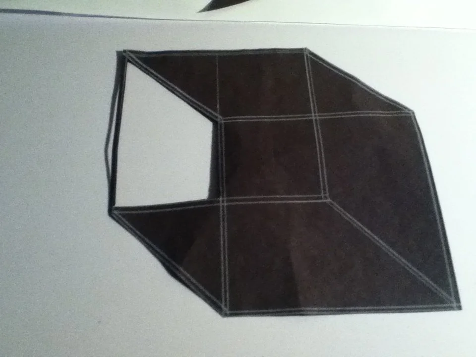 A black umbrella with a white frame, partially open, against a white background.