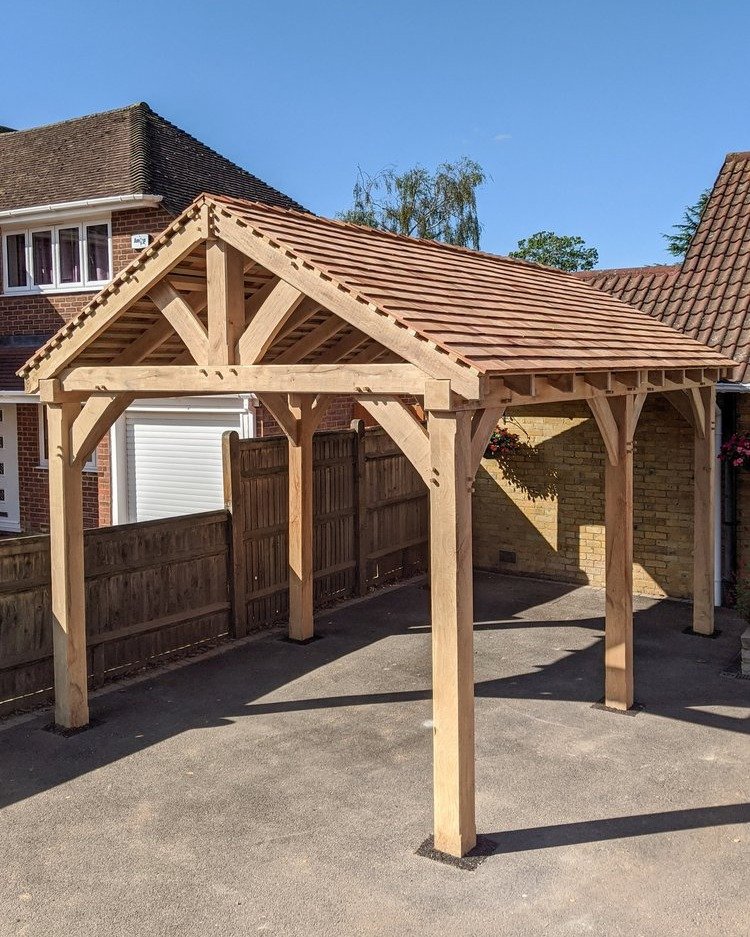 This Oak cart port was designed to reflect the architectural shapes of the client's house, creating a cohesive connection between the two structures. The cedar shingle roof and green oak will develop a range of silvery grey shades as they weather ove