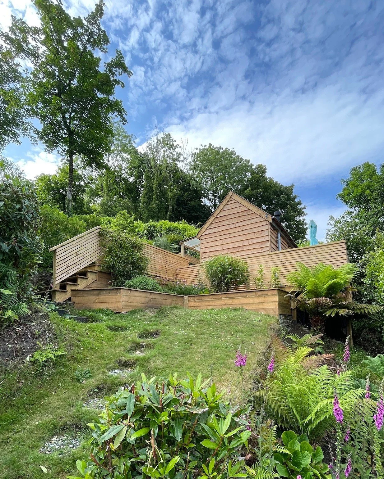 Walkway and Raised Deck 〰

The project incorporates a raised deck designed on a sloped area of the garden, creating a flat and private space that offers an impressive tree top view. The design features a horizontal slatted balustrade, enhancing the o