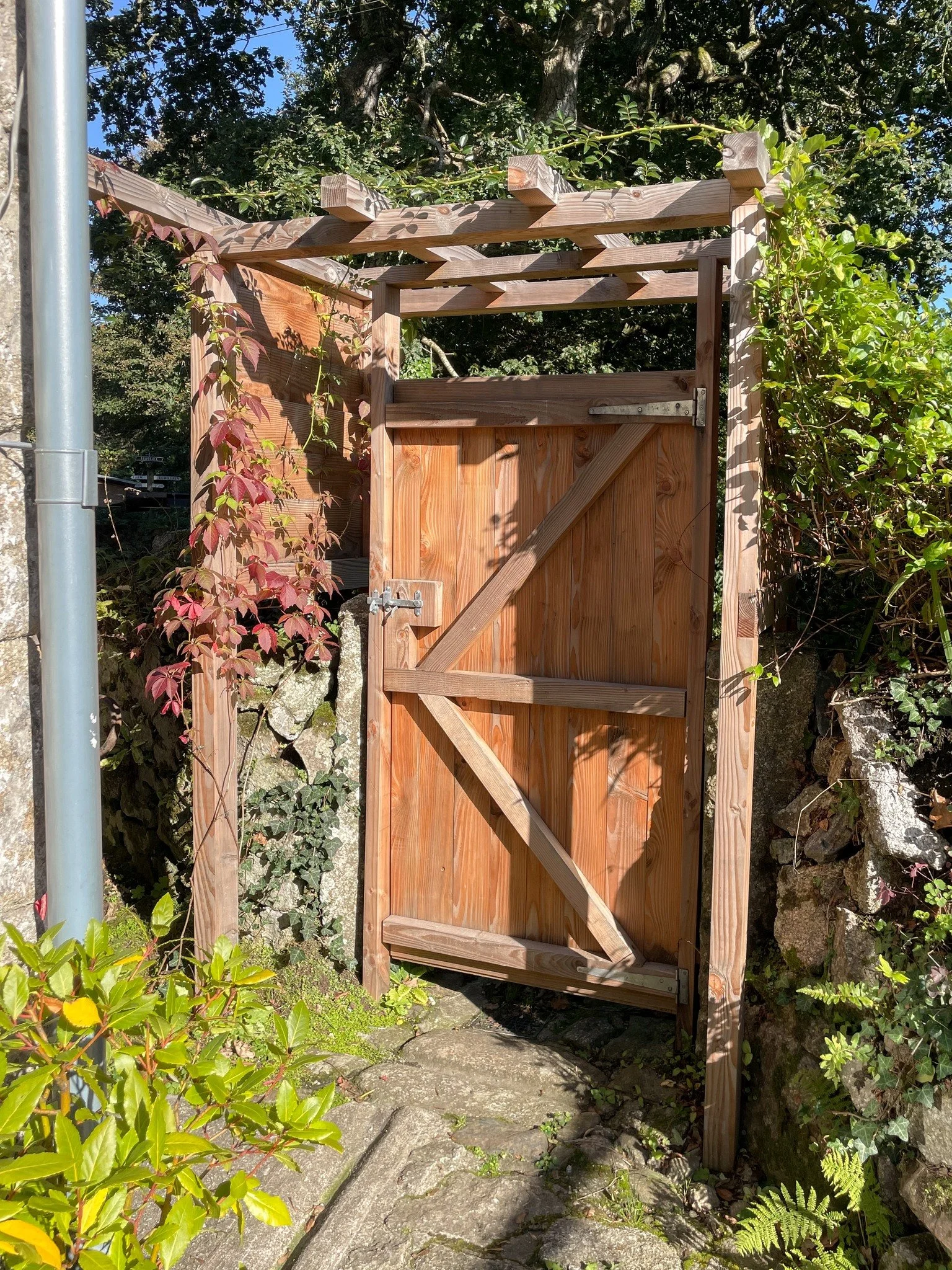A sun-baked garden gate and arch installed this spring is already weathering beautifully, becoming covered in the well-established climbers that once adorned the previous arch and gate. 〰️ 

#cornwall #cornwallgardens #pergola #gardengate #archway #d