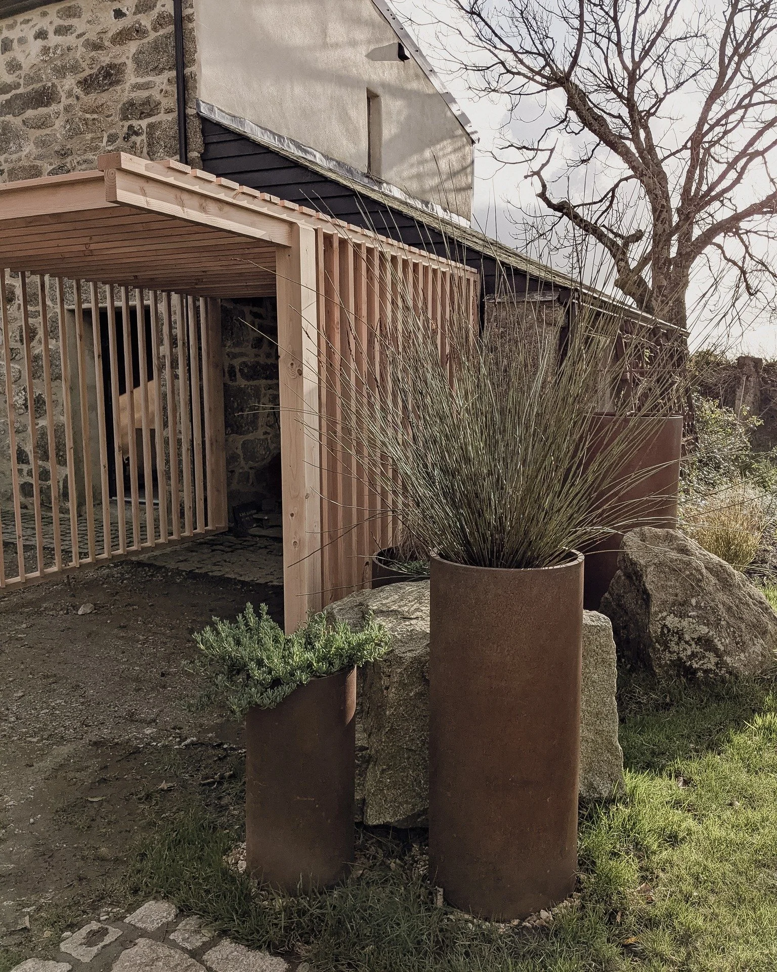 This architectural structure is designed to seamlessly combine functionality and design. It serves three main purposes: to obstruct the view and create a sense of seclusion for the annex, to enhance privacy for each living area, and to provide additi