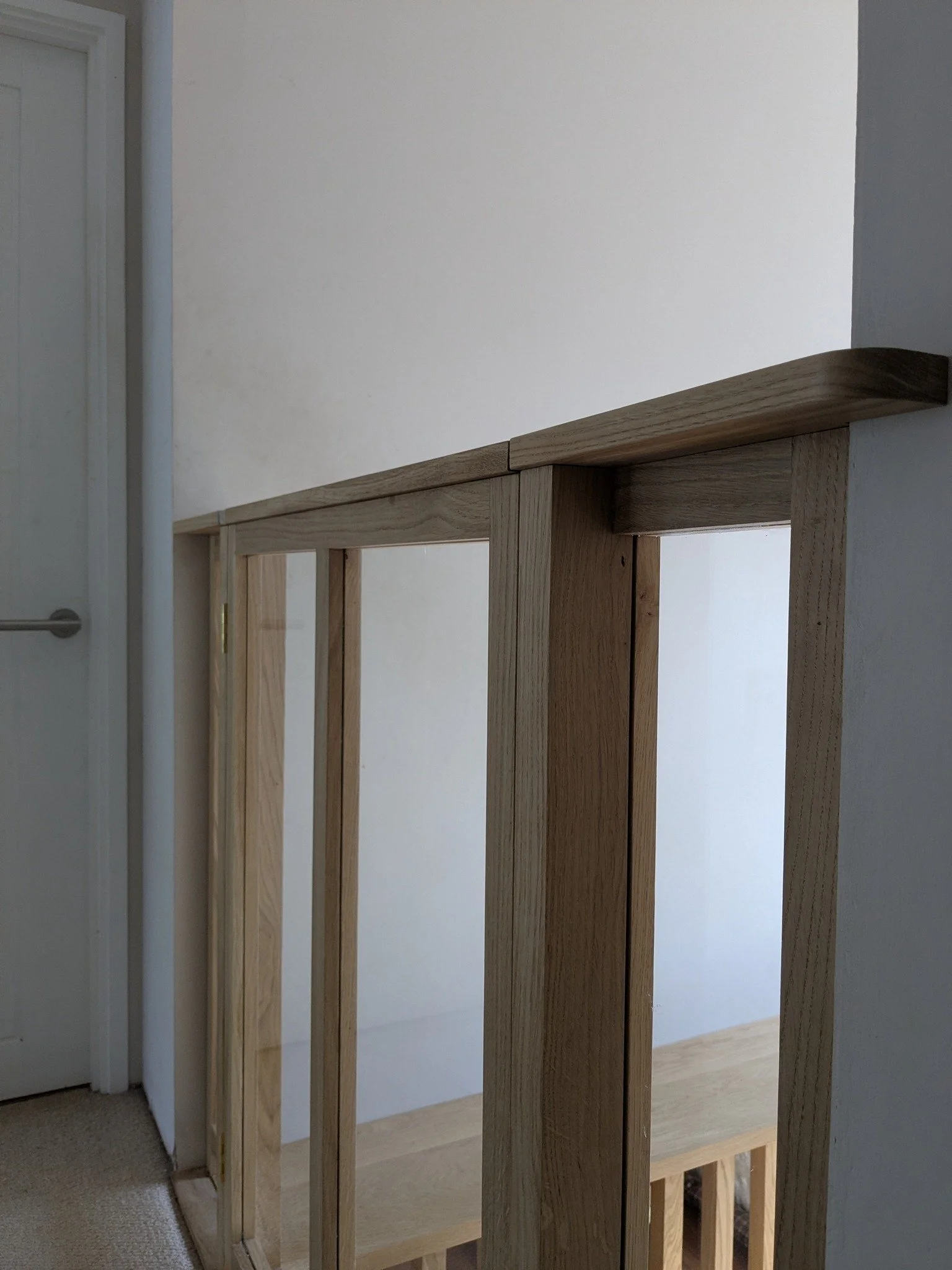 Oak balustrade and oak and toughened glass baby gate 

Originally, this solid Oak staircase had no balustrade at all. Which, with children around, wasn't the most practical. The clients wanted to keep things feeling open and light, and to continue us