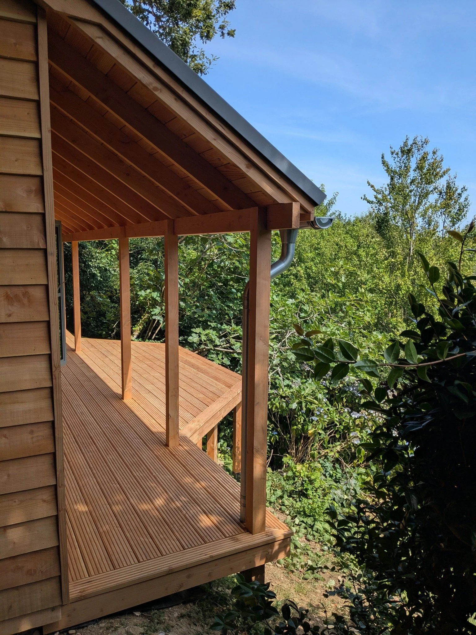 A Douglas fir-clad cabin designed around outdoor living, with a wraparound veranda that creates a beautiful transition between the cabin and its surroundings.

Sheltered beneath a zinc standing seam roof, the veranda offers a place to slow down, gath