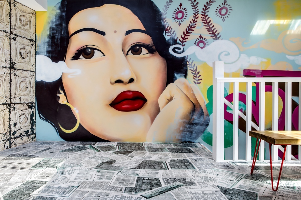 Varnished vintage Indian newspapers create a unique floor in the upstairs dining room while the stunning mural of Indian cinema legend Madhubala designed and created by Paintshop Studio Ltd keeps a watchful eye. 