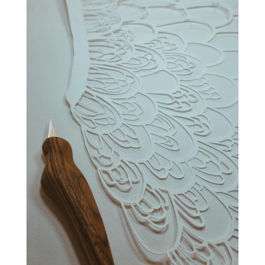 Anna's hand-cut paper artwork is infused with soul, love, and symbolism, each piece a testament to her journey of self-discovery. She uses her ErgoKiwi knife to craft these intricate designs, turning delicate paper into expressions of emotion and spi