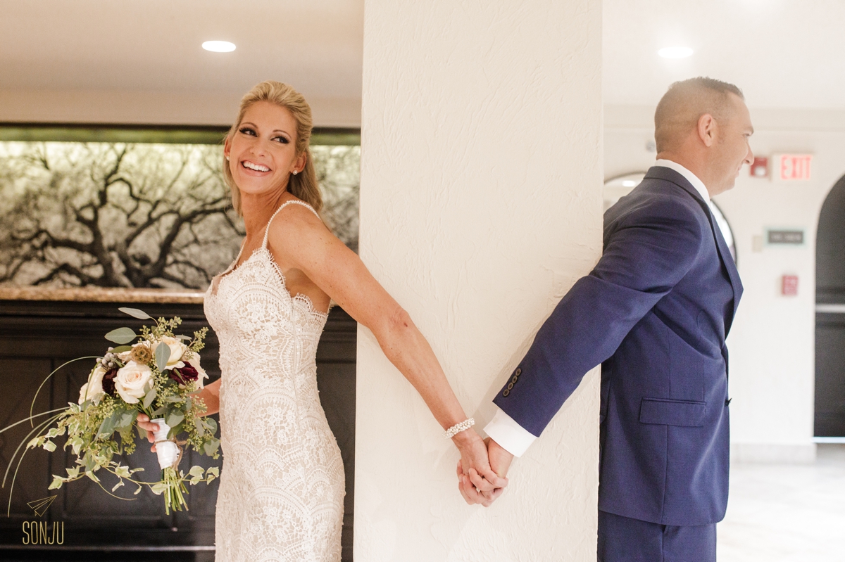 bride and groom hold hands around pillar for first touch and prayer before their ceremony