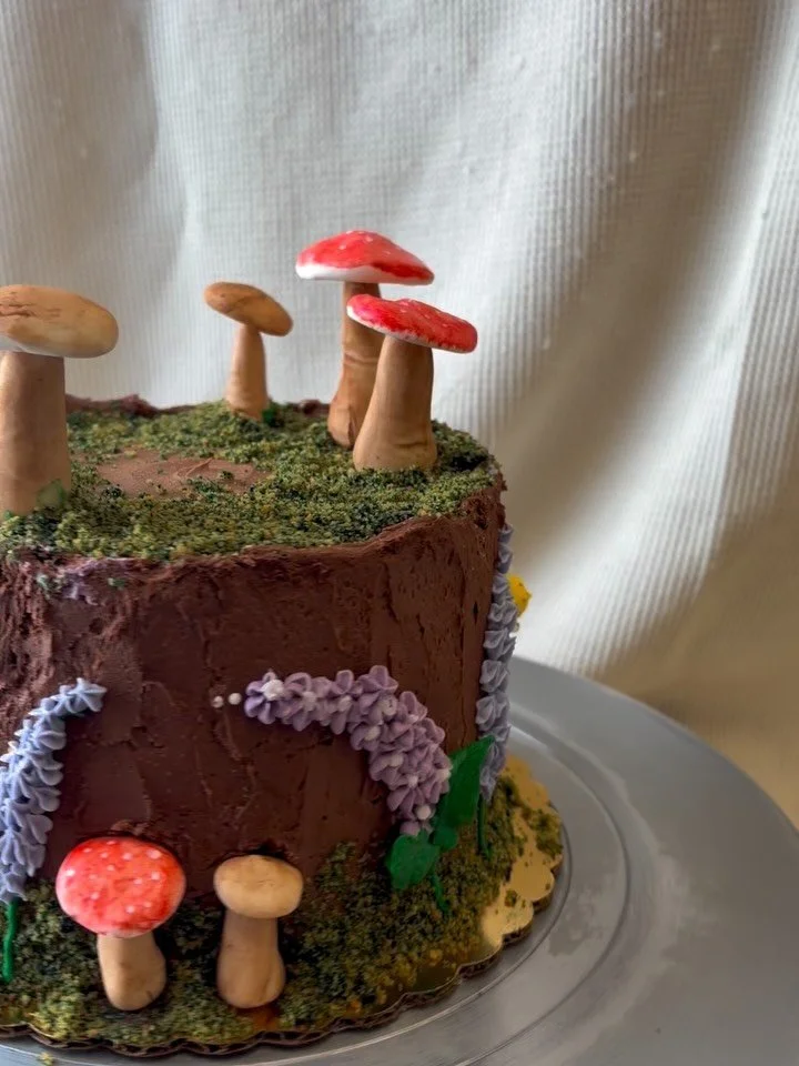 ✨ 🍄&zwj;🟫 She Was a Fairy Cake 🍄&zwj;🟫 ✨ Another beautiful staff birthday cake made by our decorator Jenn. This vegan triple chocolate cake is perfected with fondant mushrooms, graham cracker moss and frosting lilacs. #glutenfreevegan #glutenfree