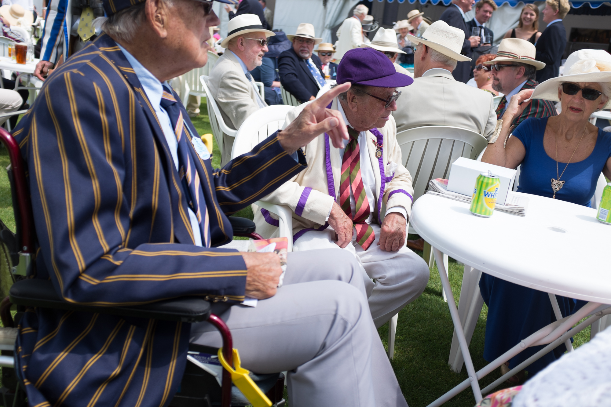  Catching up over drinks at the Bridge Bar at Henley Royal Regatta. Lots of spectators have been coming to the regatta for a great many years, and still wear their club colours with pride. 