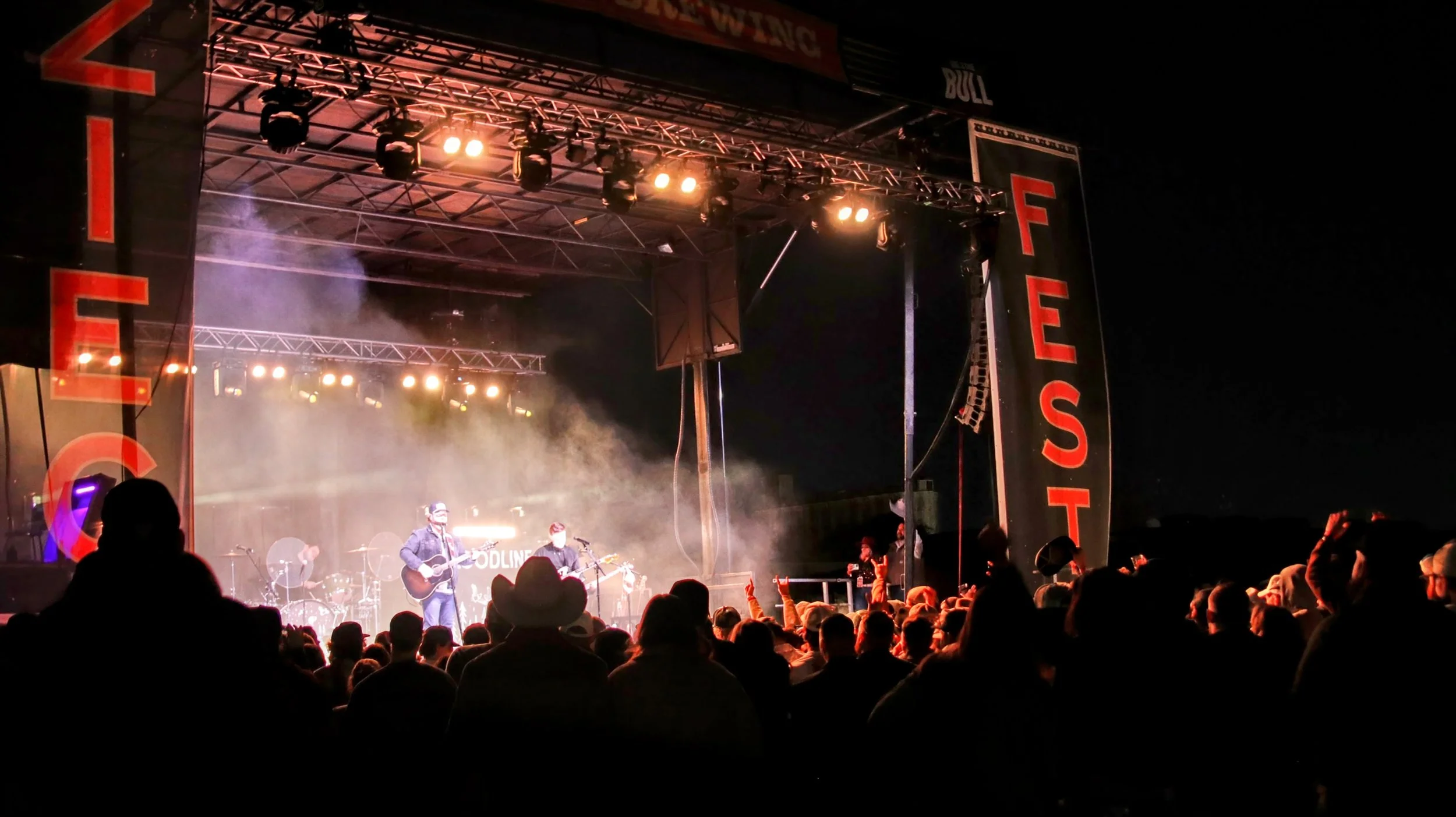 Nighttime concert with dramatic stage lighting and fog effects, drawing a lively crowd — showcasing WBSAV’s expertise in outdoor event production and live performances.