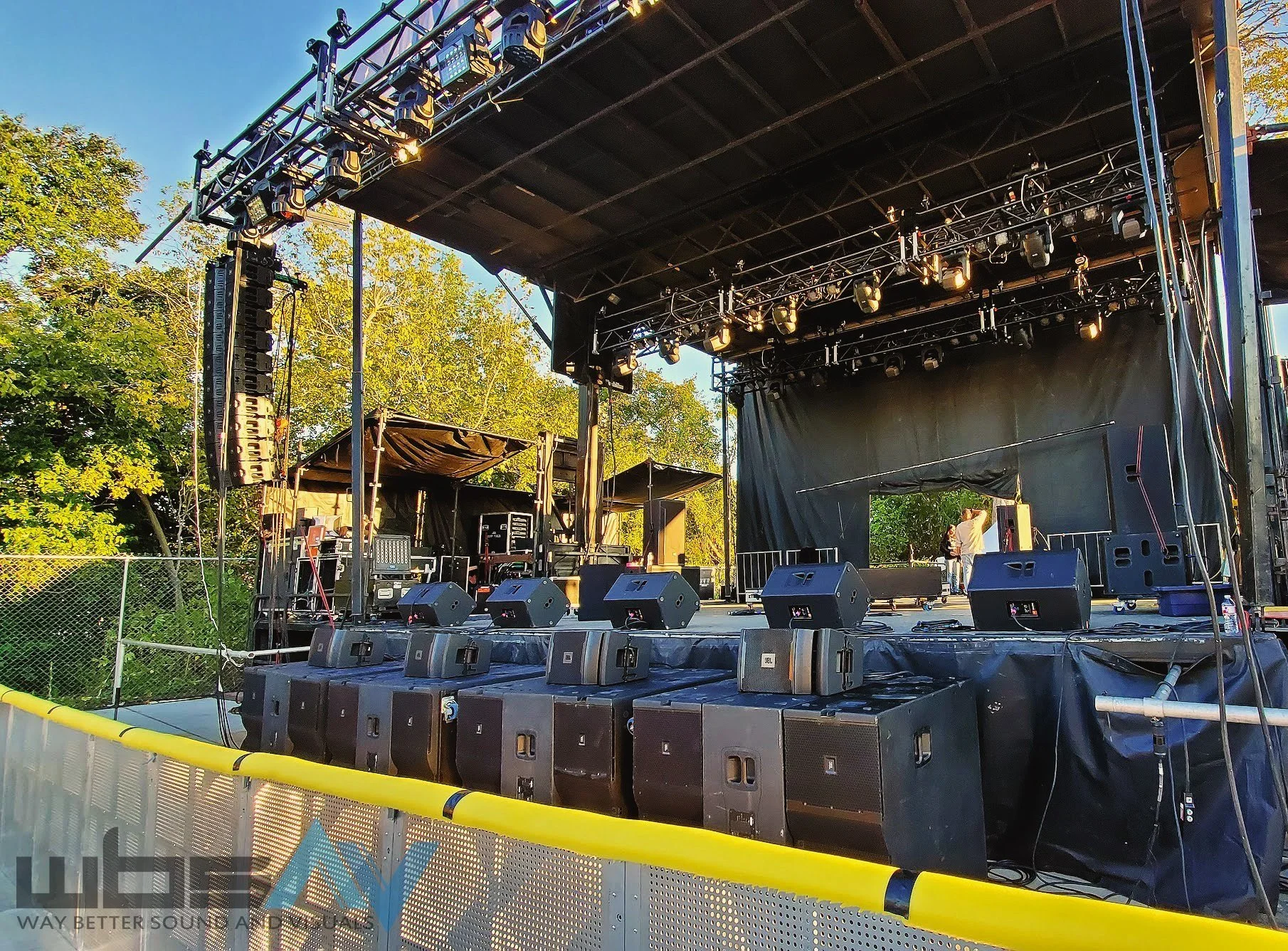 Mobile outdoor stage with roof and full AV setup, surrounded by trees and natural daylight — ideal for festivals, outdoor concerts, and seasonal community events.