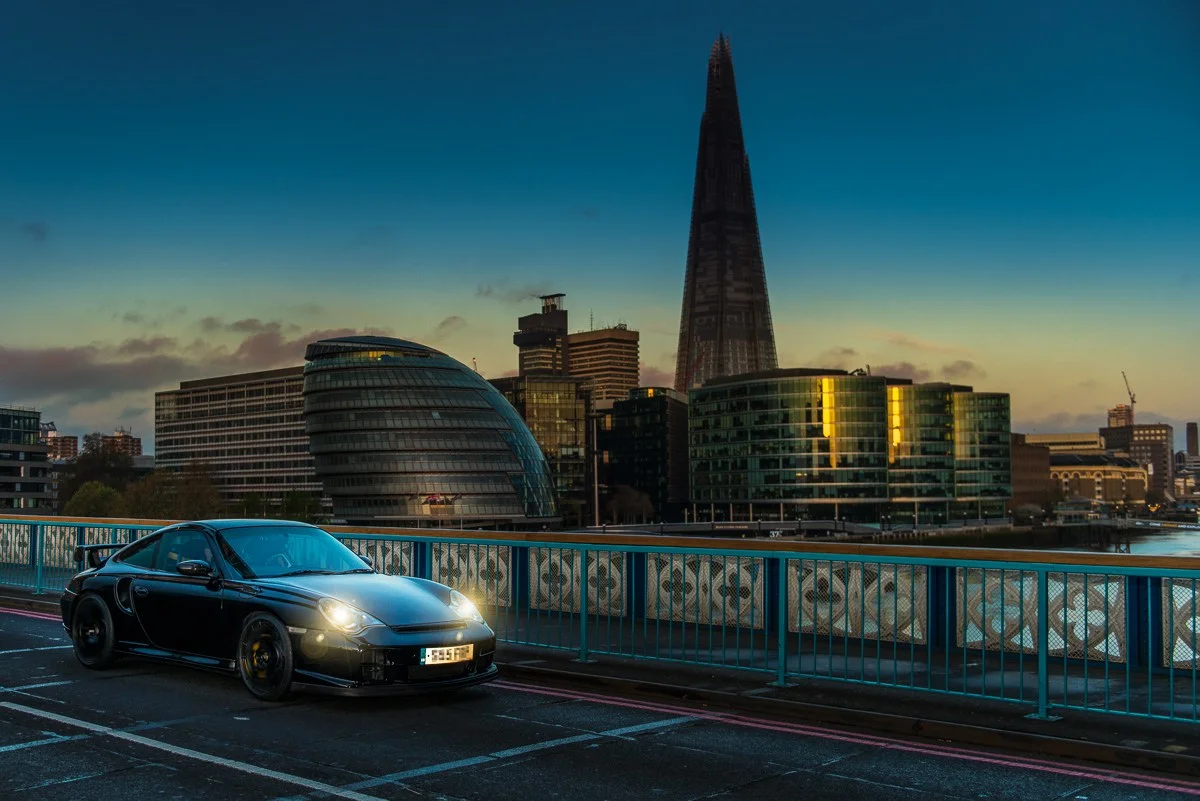 Porsche 996 driving over London Tower Bridge with the Shard lit up with the sunrise