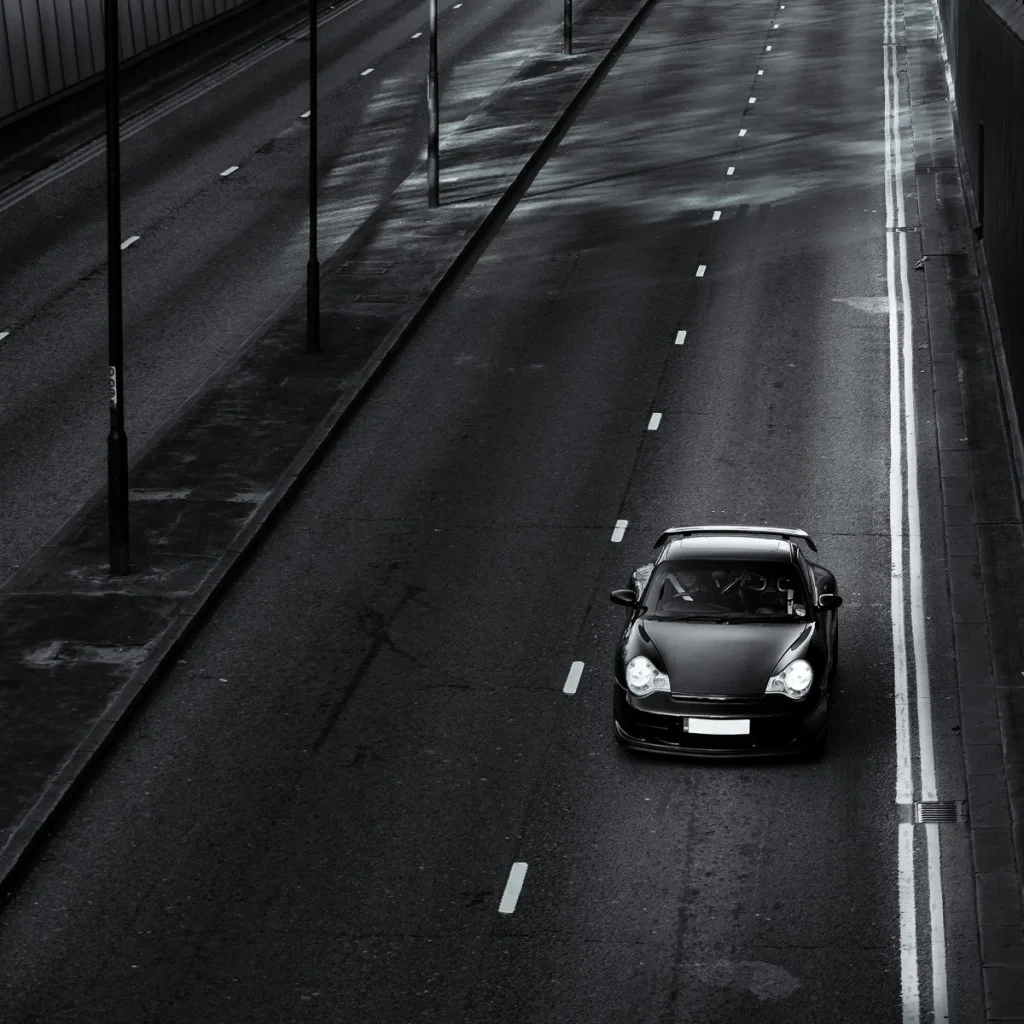 Porsche 996 driving down an empty road
