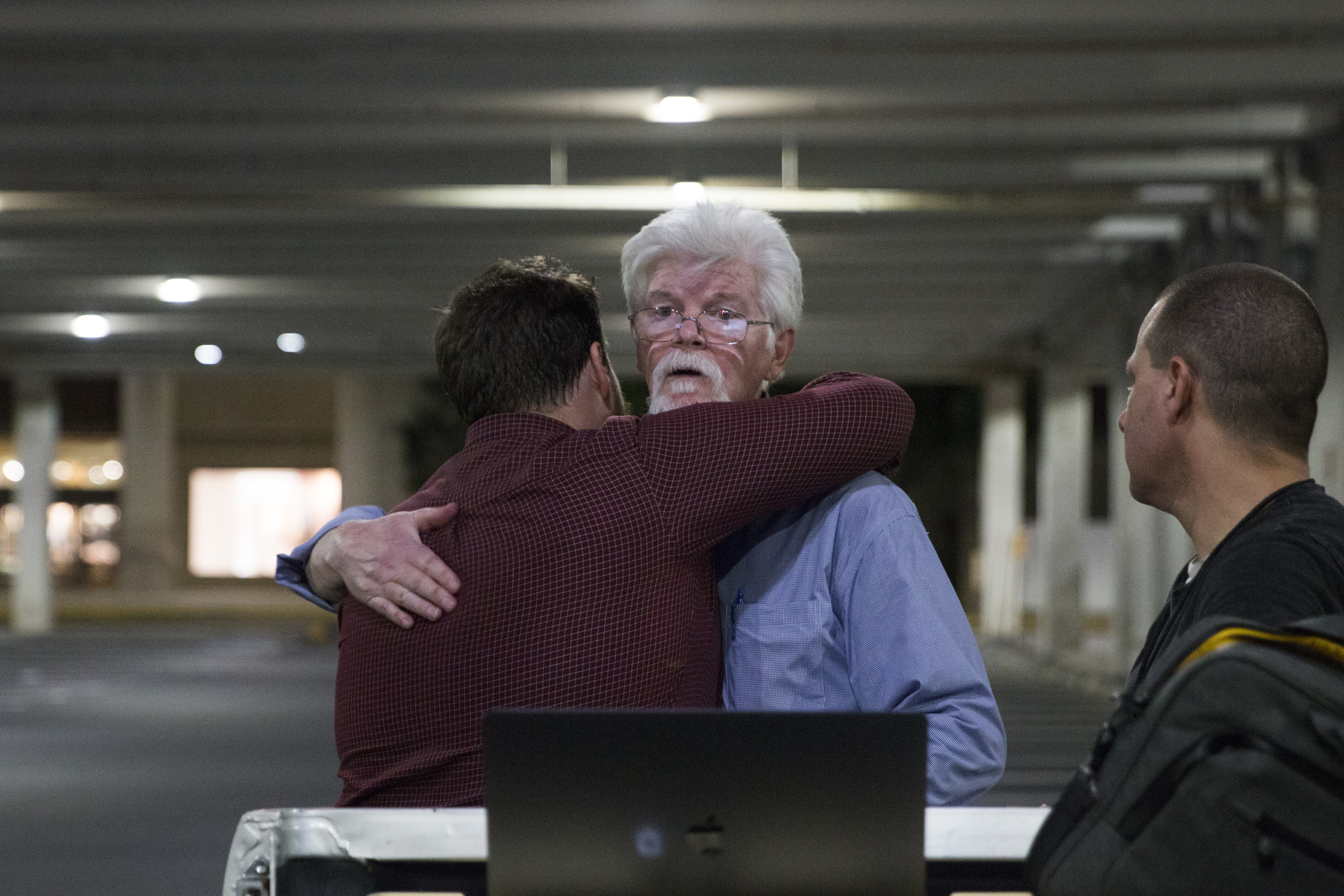  Capital reporters Pat Furgurson and Chase Cook, surviving journalists of the deadliest attack on a newsroom in modern U.S. history, hug goodbye after finishing writing the story for the next day’s paper in a parking lot across the street from their 
