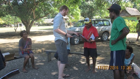 Dylan Gaffney presenting booklets to Kubei Balifun (community leader) at Bilbil village, Madang, PNG. Photo: Dylan Gaffney, 2016.