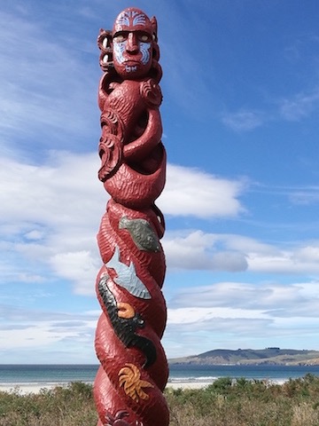 Takaroa/Tangaroa. Carved pou at Warrington Beach, Dunedin. Carved by members of Te Whare Wananga o Te Whānau Arohanui, Watiati, Dunedin, the spirals represent the past, present, and future generations of kaitiaki for the resources around the East Otago coastline—the domain of Takaroa. It stands at the interface between sea and land. Photo: Lyn Carter.