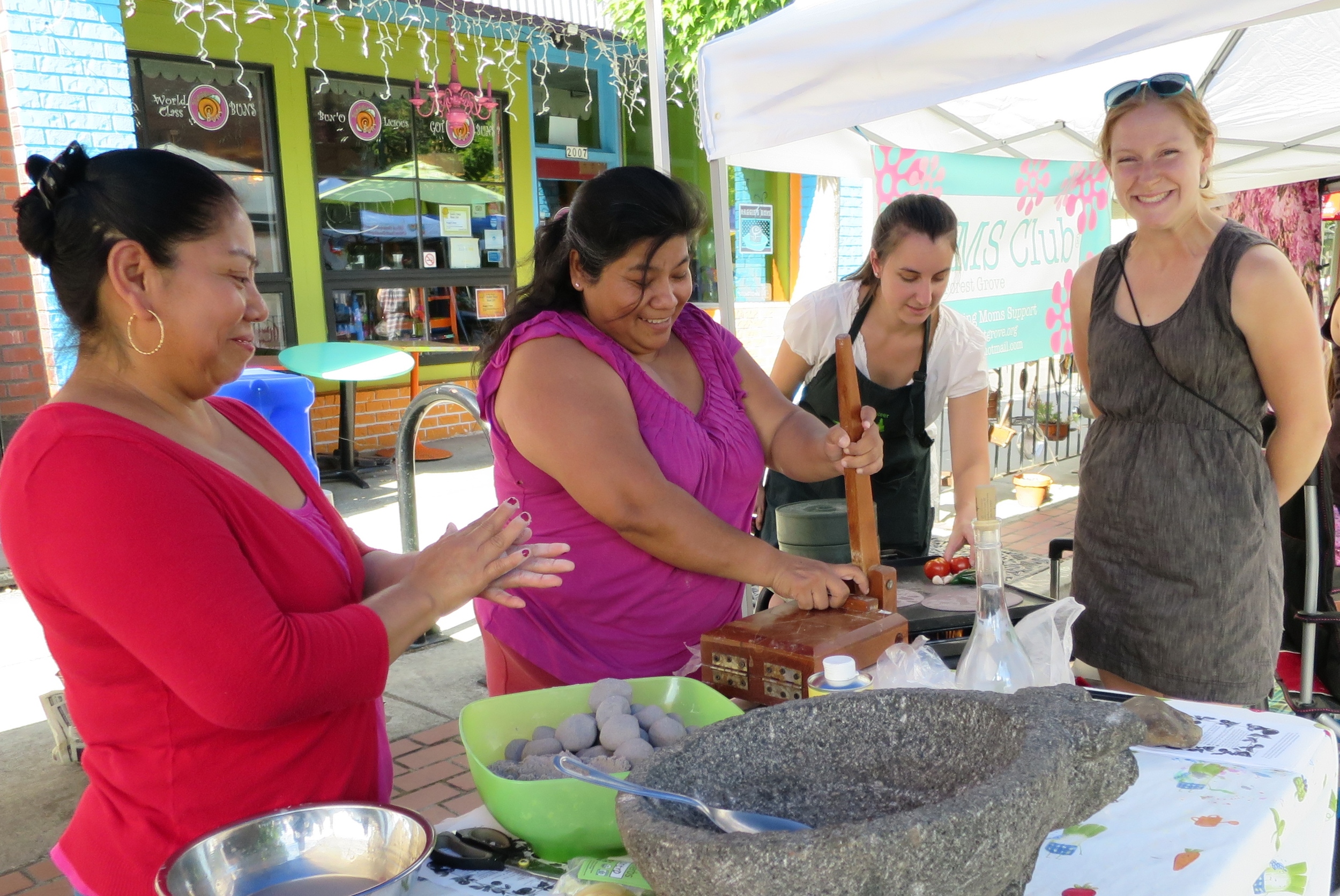 Marcella helps with a cooking activity at The Forest Grove Farmers MArket Last Year. 