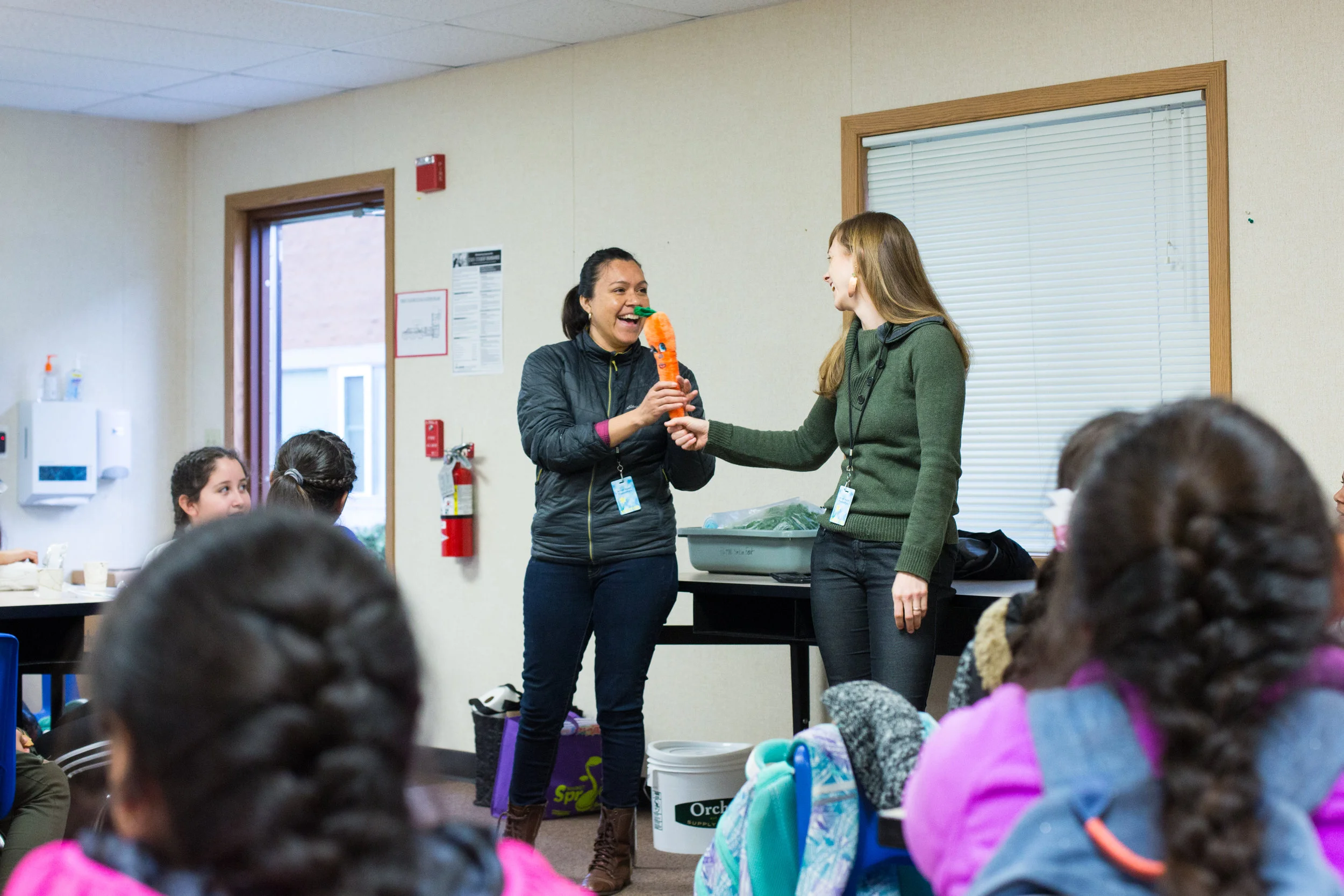 Mayra Hernandez (left), Sustainable Agriculture & Nutrition Coordinator, and Kaely Summers (right), Forest Grove Farmers Market Manager, begin their nutirion session with the Chicas.