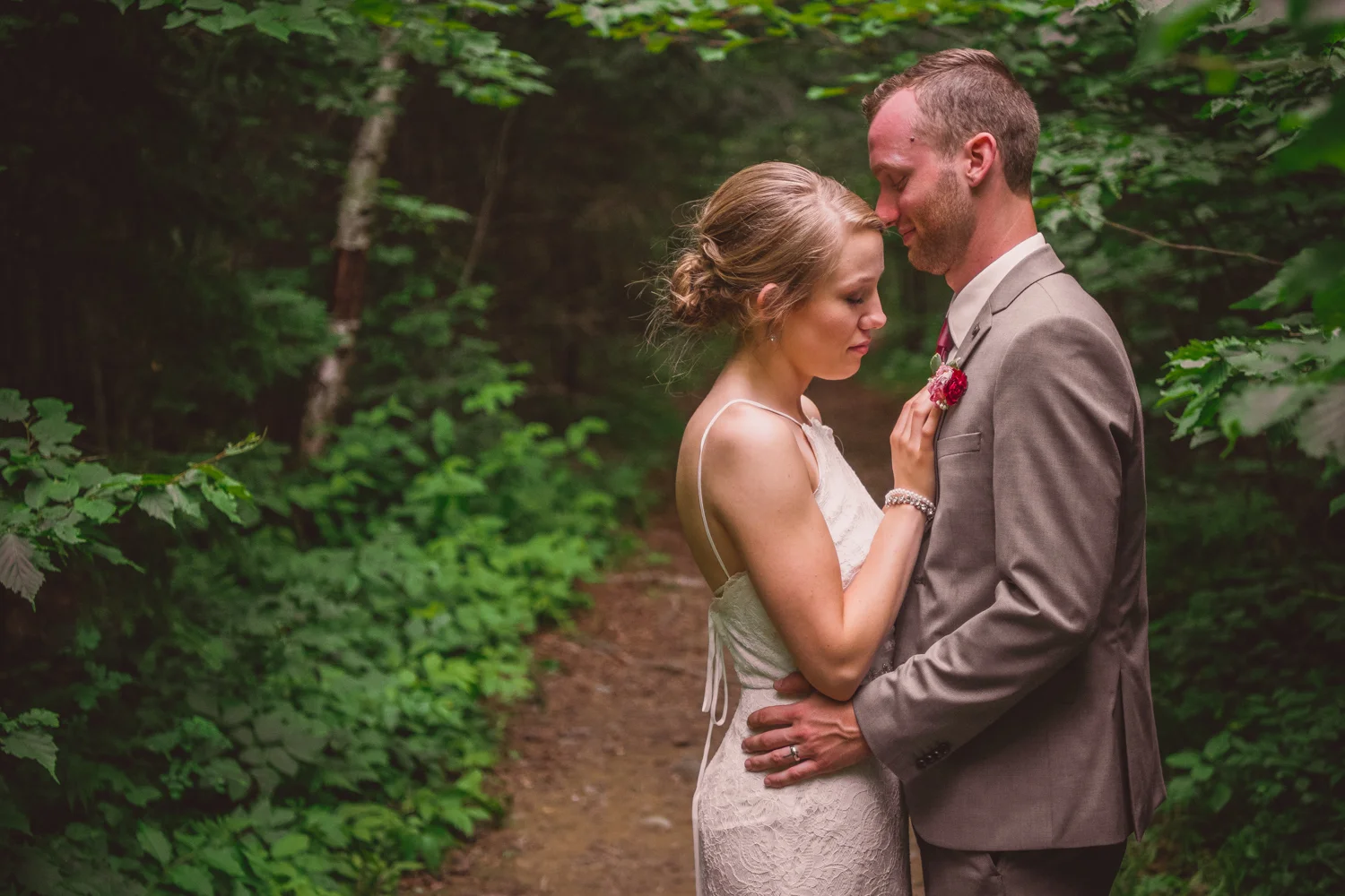 The bride and groom hold each other close as husband and wife in the woods of New Brunswick.