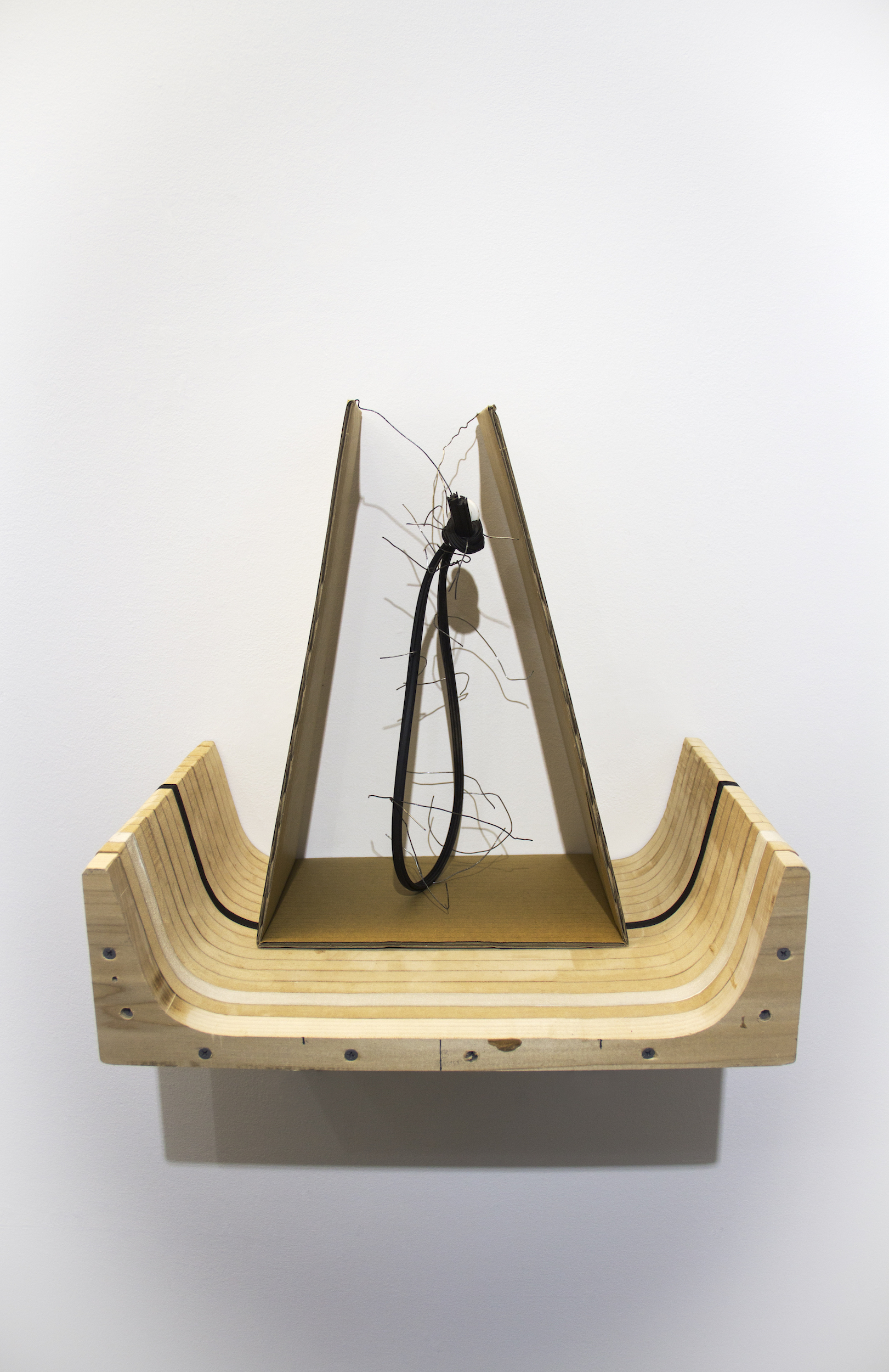    The cradle    Used wire from funeral tent and cardboard packaging; found wooden structure, rubber tubing, plastic knob; and acrylic paint  Approx. 17 6/8 x 12 6/8 x 16 1/2 inches  2019 