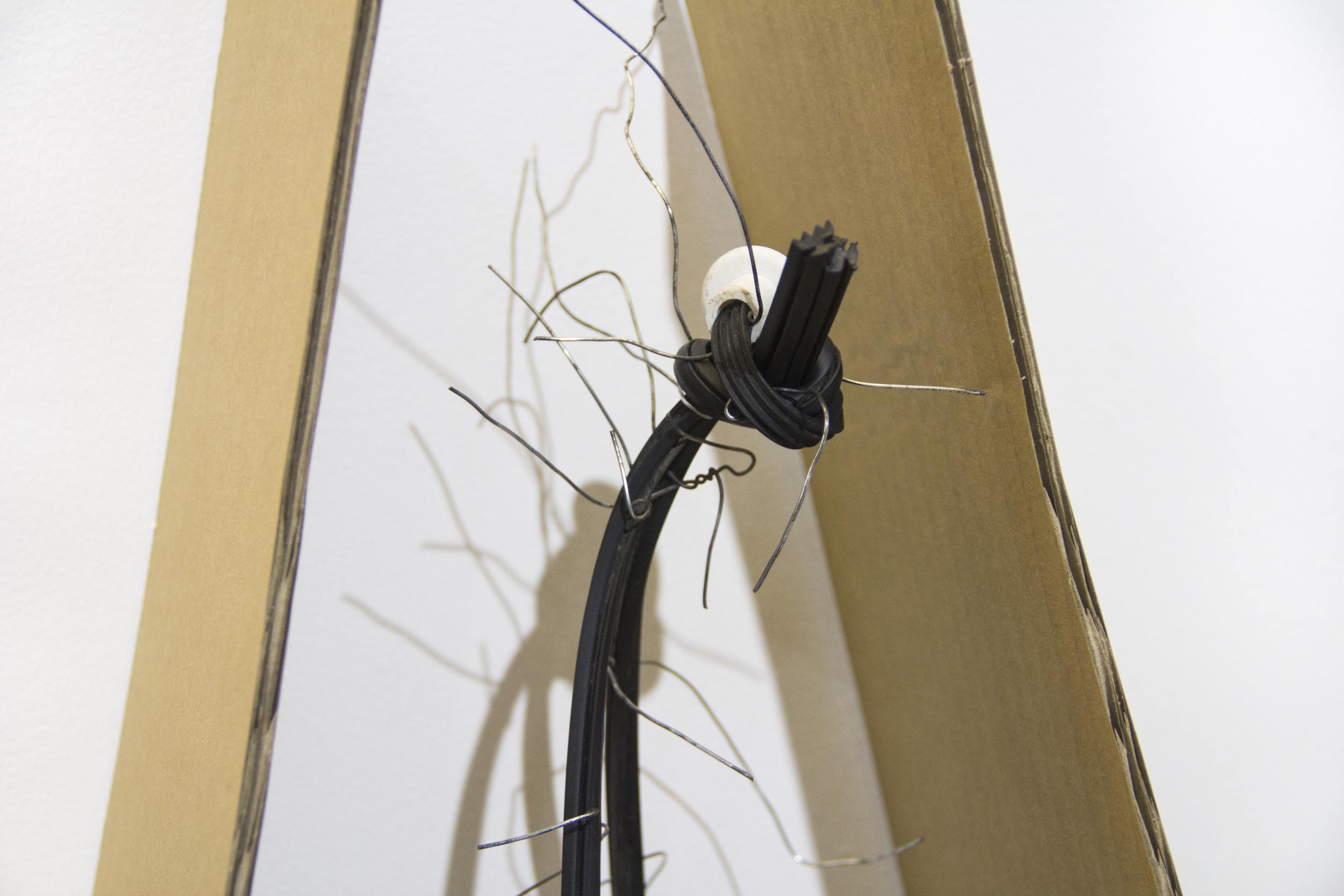    The cradle   (detail)  Used wire from funeral tent and cardboard packaging; found wooden structure, rubber tubing, plastic knob; and acrylic paint  Approx. 17 6/8 x 12 6/8 x 16 1/2 inches  2019 