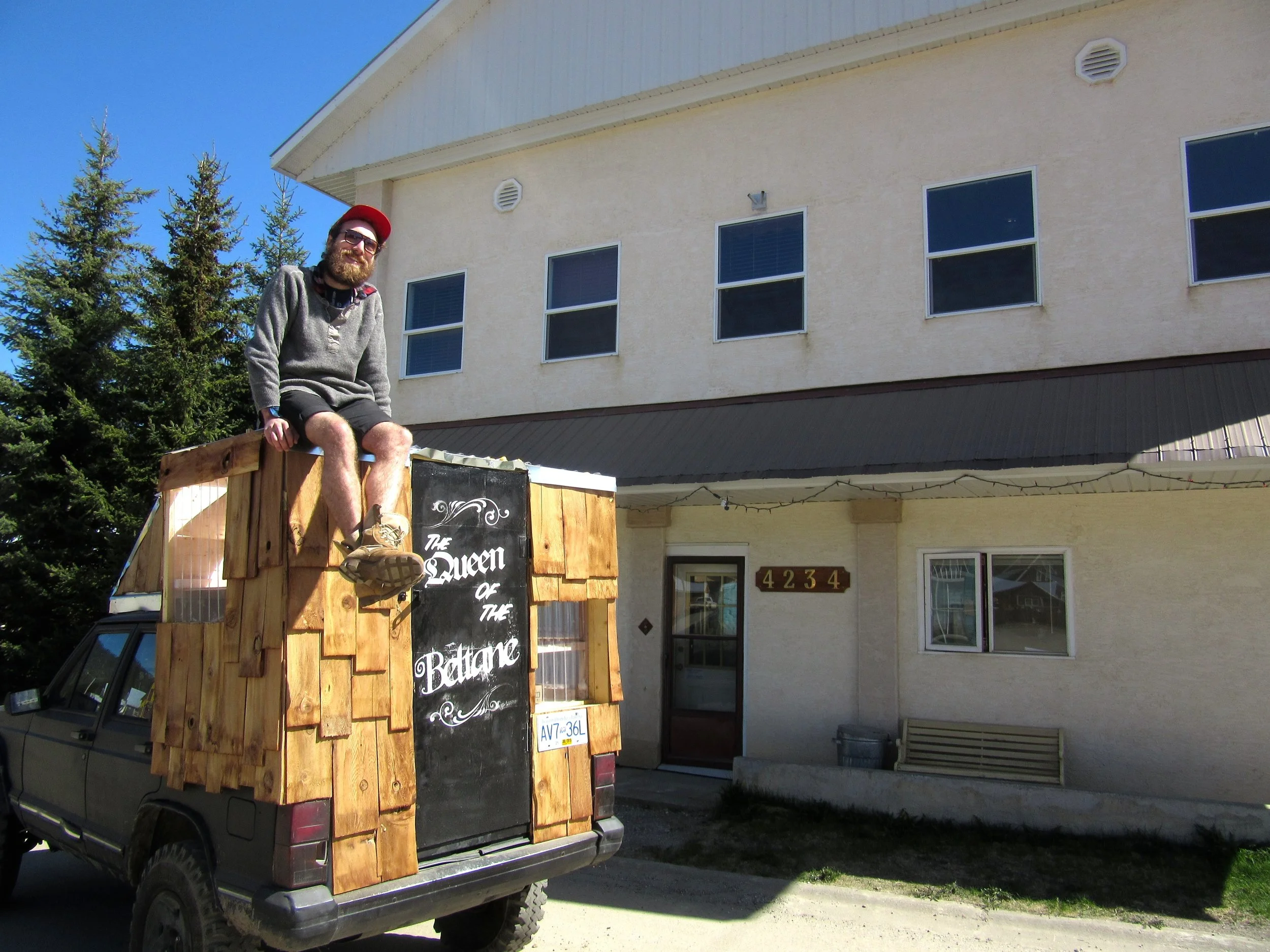Aubrey Burke in front of Residence building and on top his homemade truck-camper. Photo by Ksenya Dorwart.