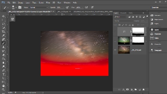 This screenshot from Photoshop shows the two layers, and the mask used to block the bottom of the top layer (the dark sky) to allow the bottom of the bottom layer (the landscape) to come through. 