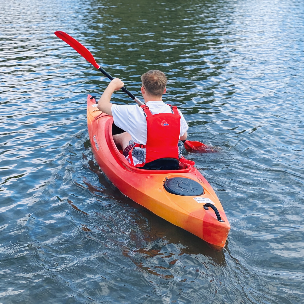 Kayaker in vibrant orange kayak.png