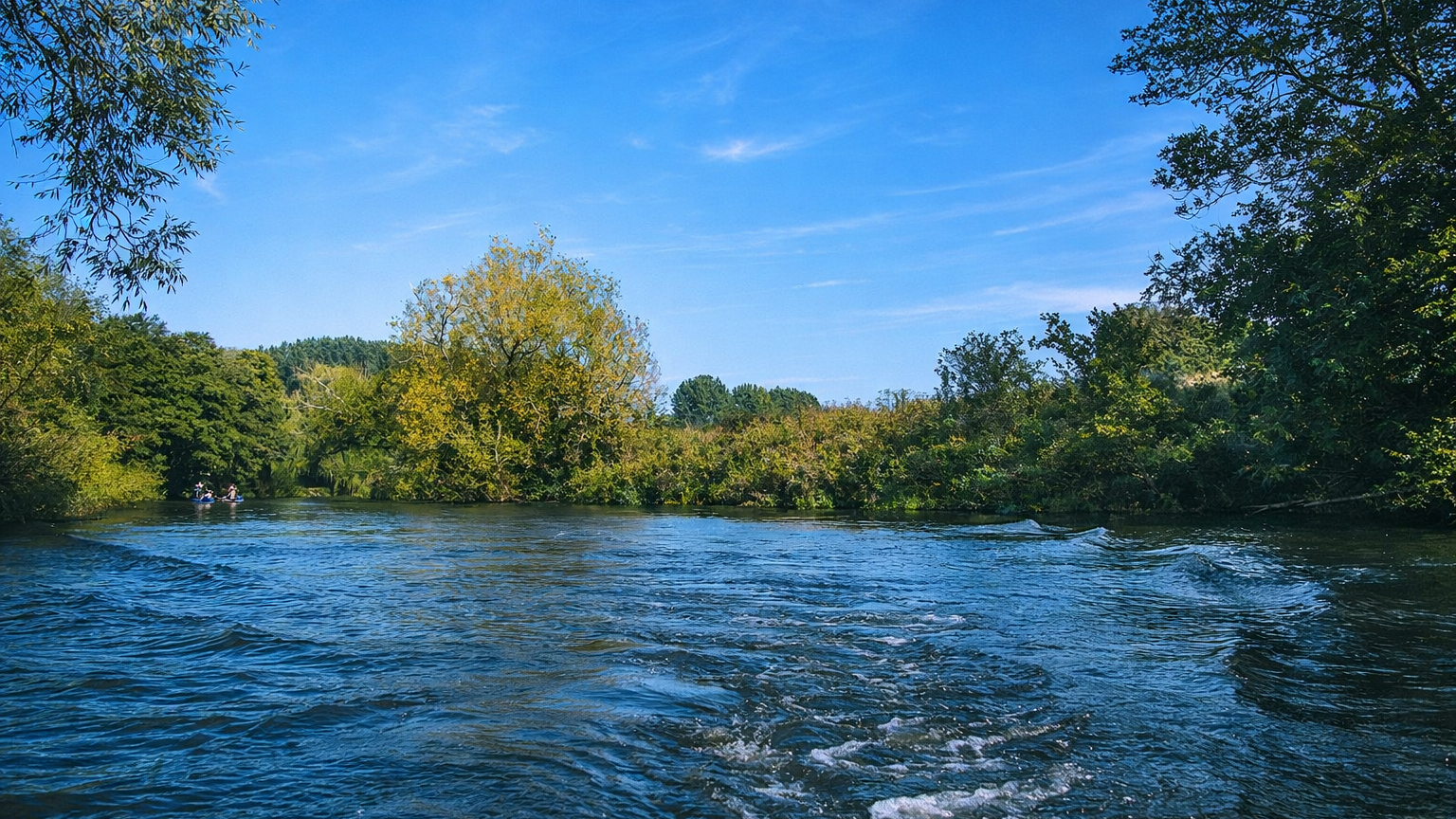 Serene river with kayakers in view.png