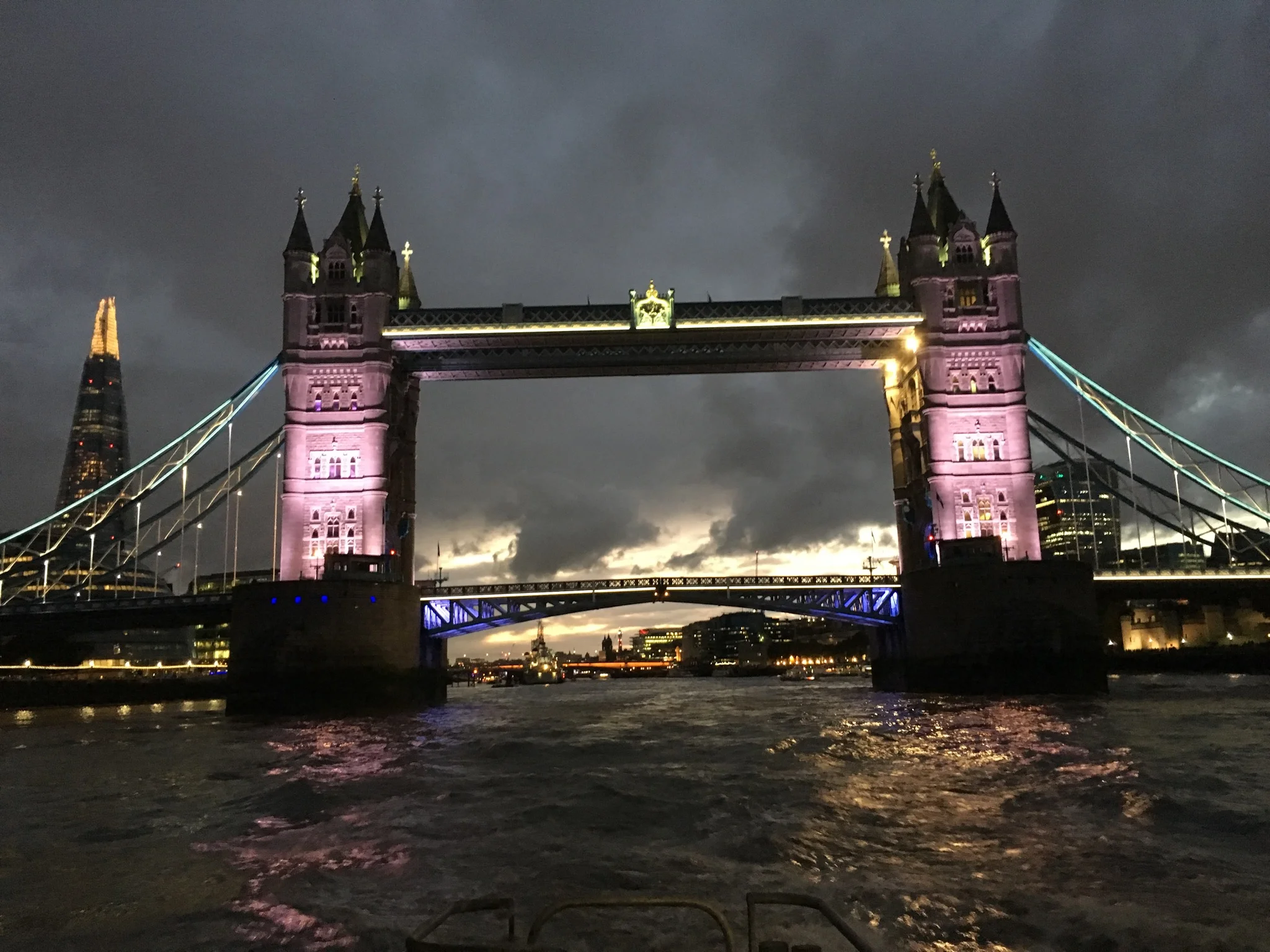 Tower Bridge at night while on the River Thames.