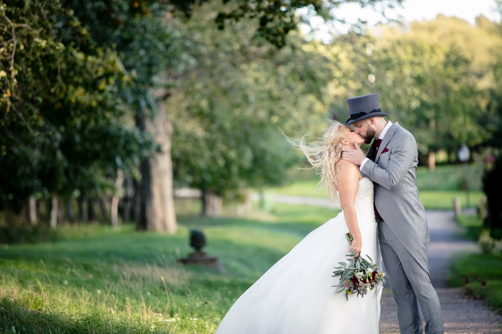 Bröllopsfotograf Linköping — Sofie & Reine, Bjärka Säby, passionerad kyss av brudparet längs med grusvägen 