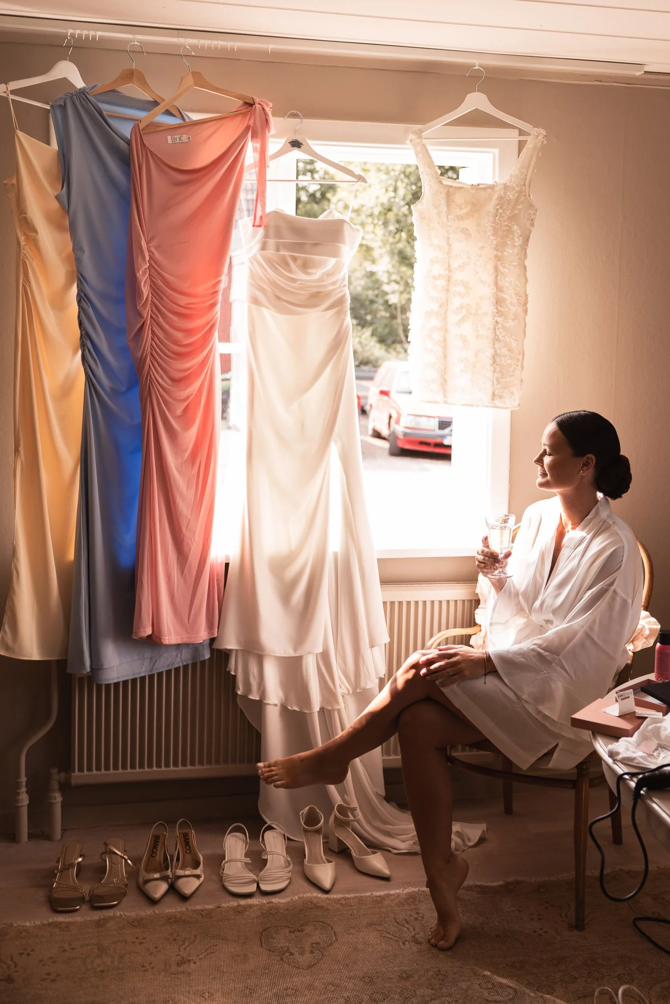 Bröllopsfotograf Västerlösa — Alice & Joakim, Olais Lada, bruden tar en paus under förberedelserna och tittar på sin klänning och tärnornas 