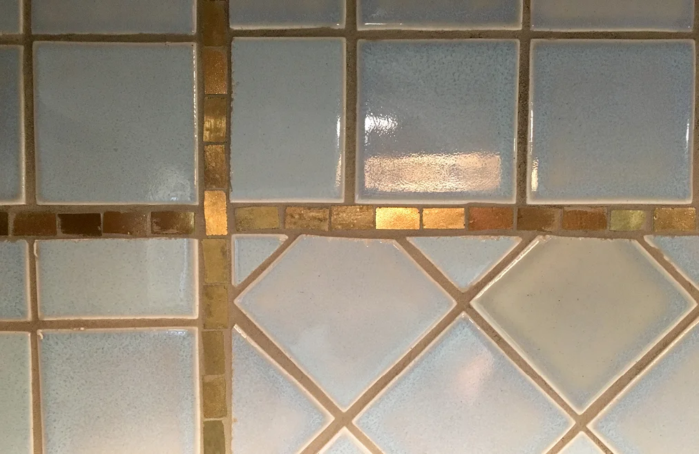 Simple custom 24k gold mosaic backsplash border design.