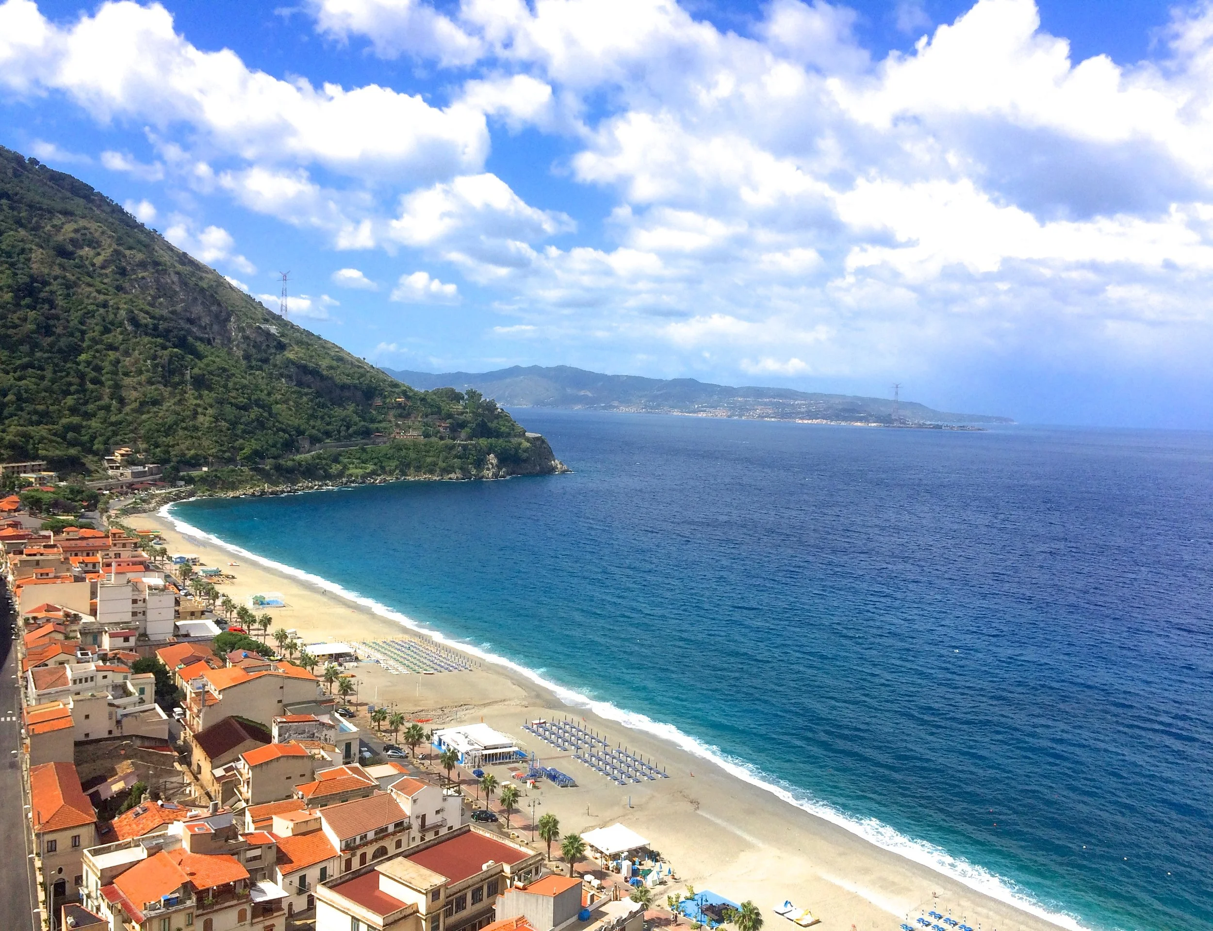 Scilla's beautiful mermaid beach with a view of Sicily in the distance.