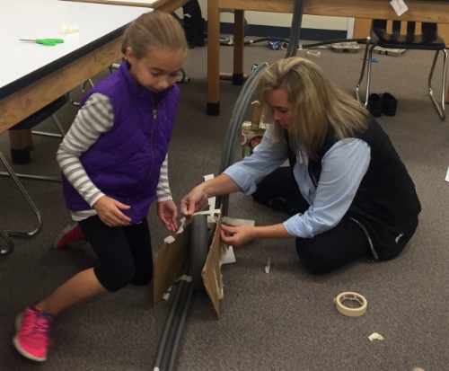 A mom and daughter work on building a "marble roller coaster" in our Build Bridges! program