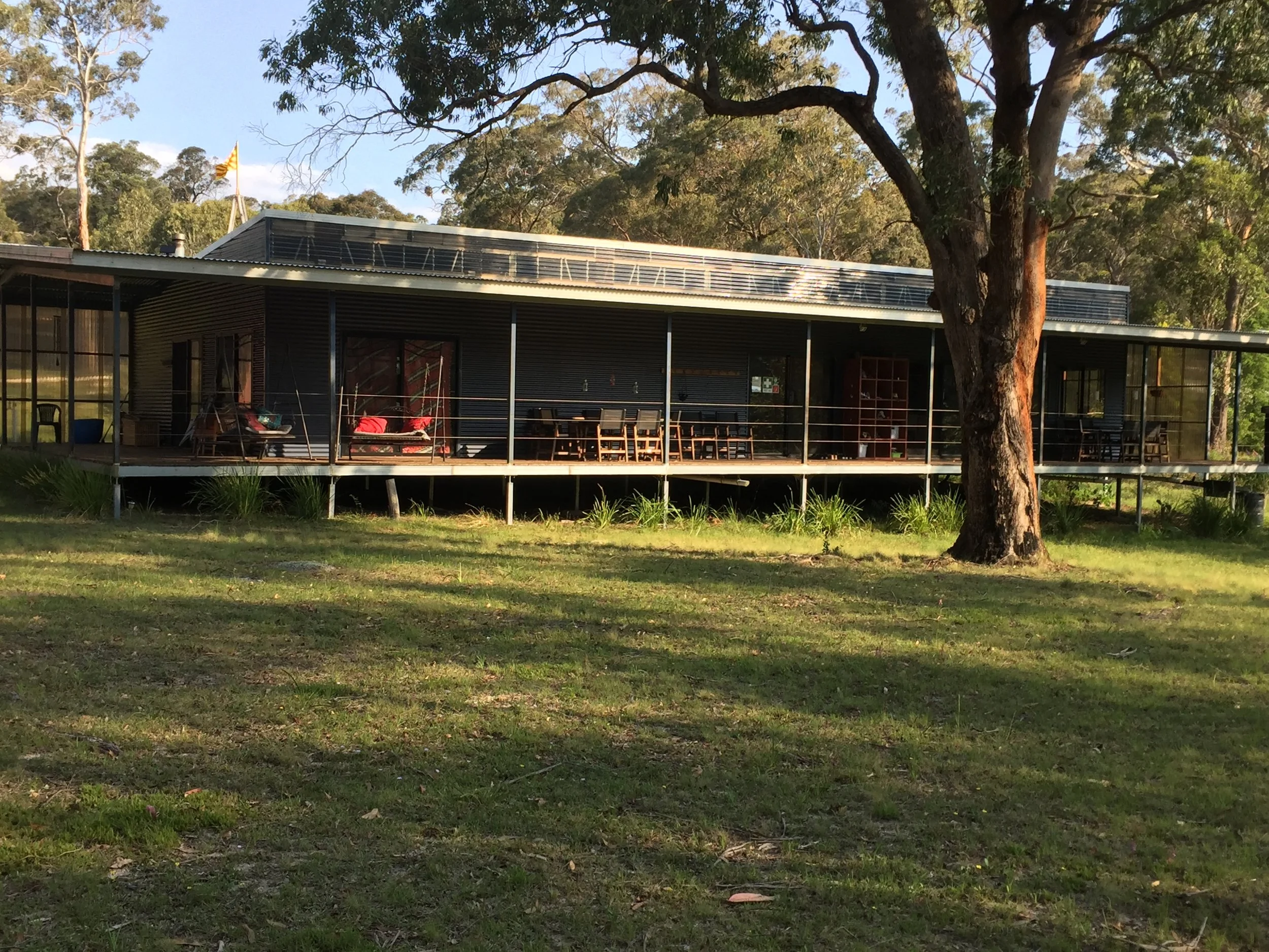 'The Ark' : the meditation and music space , with adjacent dining and open kitchen, and old fashioned verandah looking into the forest and creek.