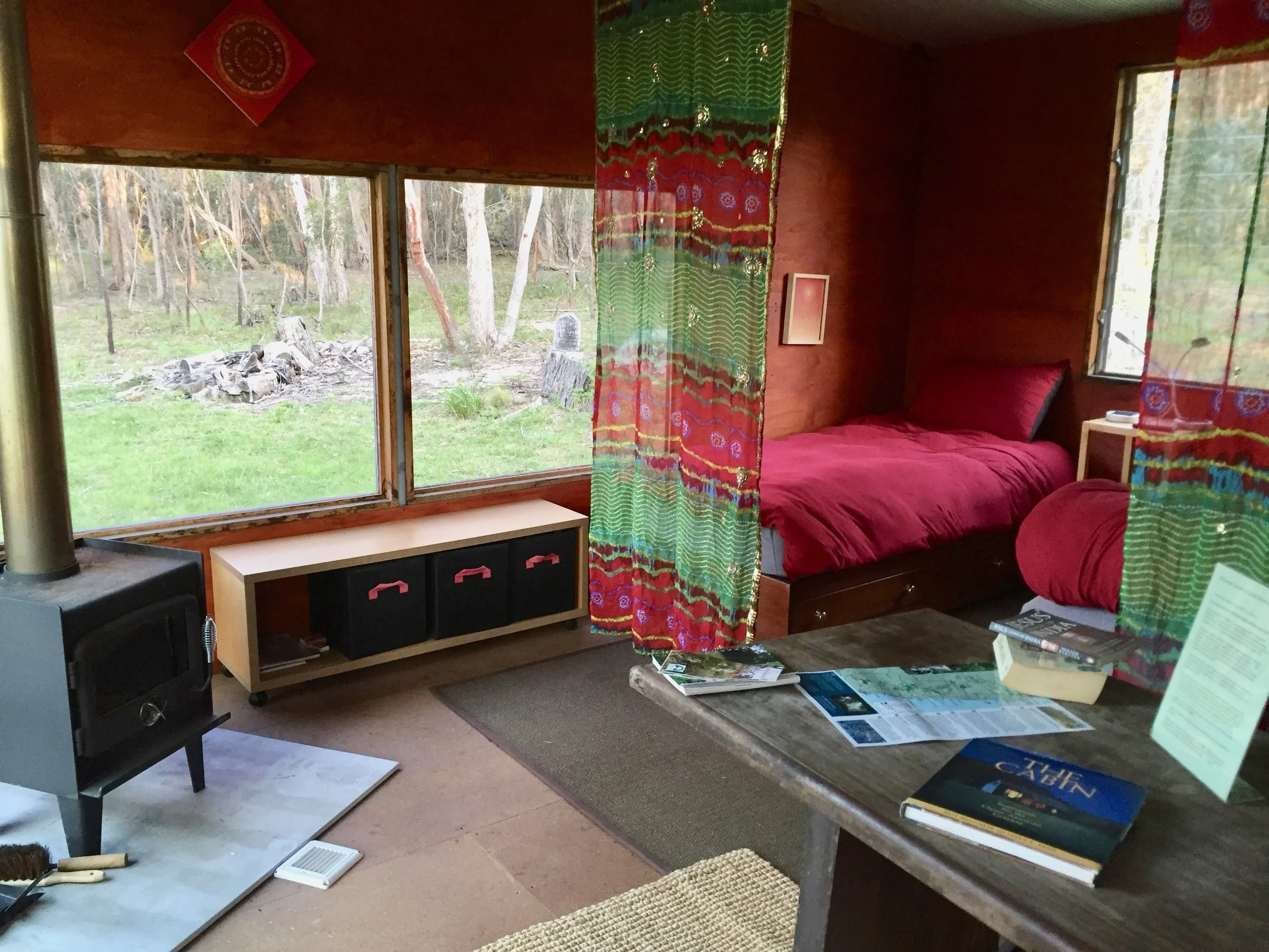 Inside one of our attractive guest studios: well insulated and heated by its own wood stove, with great views to the forest, and wildlife.