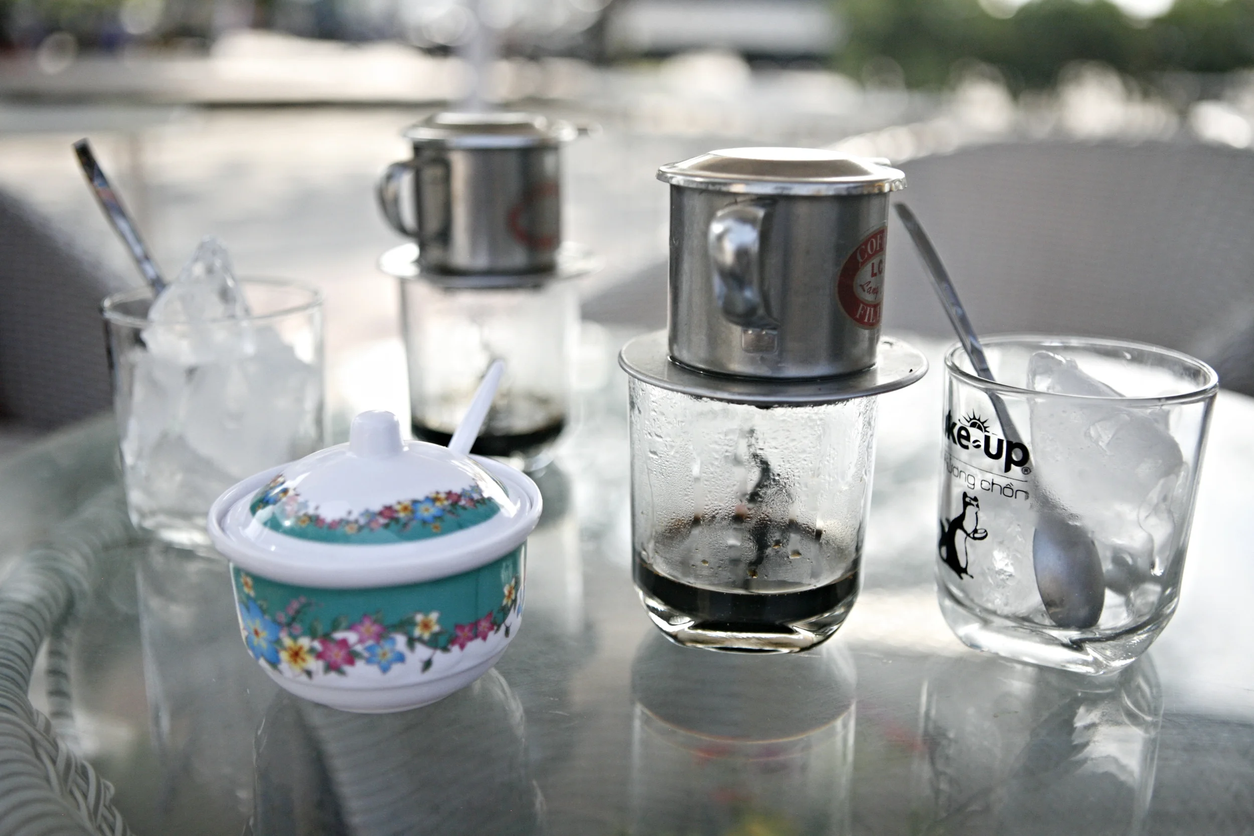 Morning ca phe sua da brewing in single serving stainless steel pots