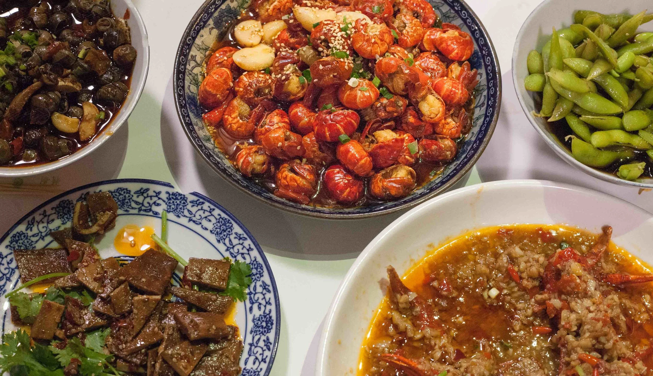 Clockwise from top - crawfish tails, pickled soy beans, whole crawfish in garlic and chili, smoked bean curd, sea snails.