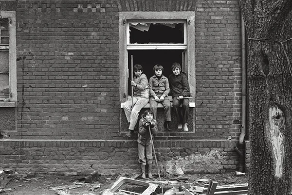 Ein Haus in der Kruppsiedlung Altenhof I in Essen- Rüttenscheid 1978. Jugendliche spielen in Ruinen wie schon ihre Eltern. Der Abriss-Bagger ist bereits am Werk, schafft Platz für einen Krankenhausneubau.