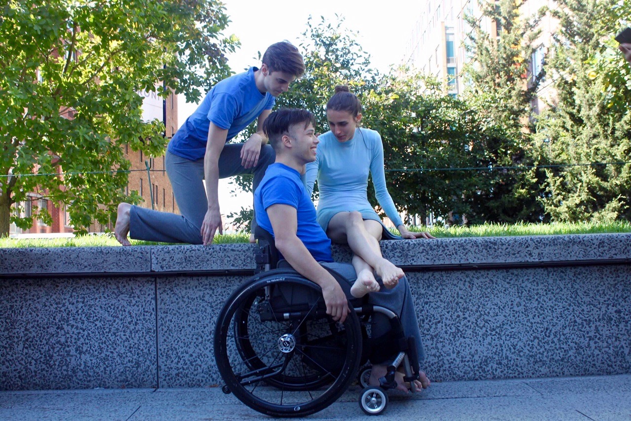 Dancers Jake Elvig, Peter Trojic, and Bec Bogue seated at the High Line and talking.