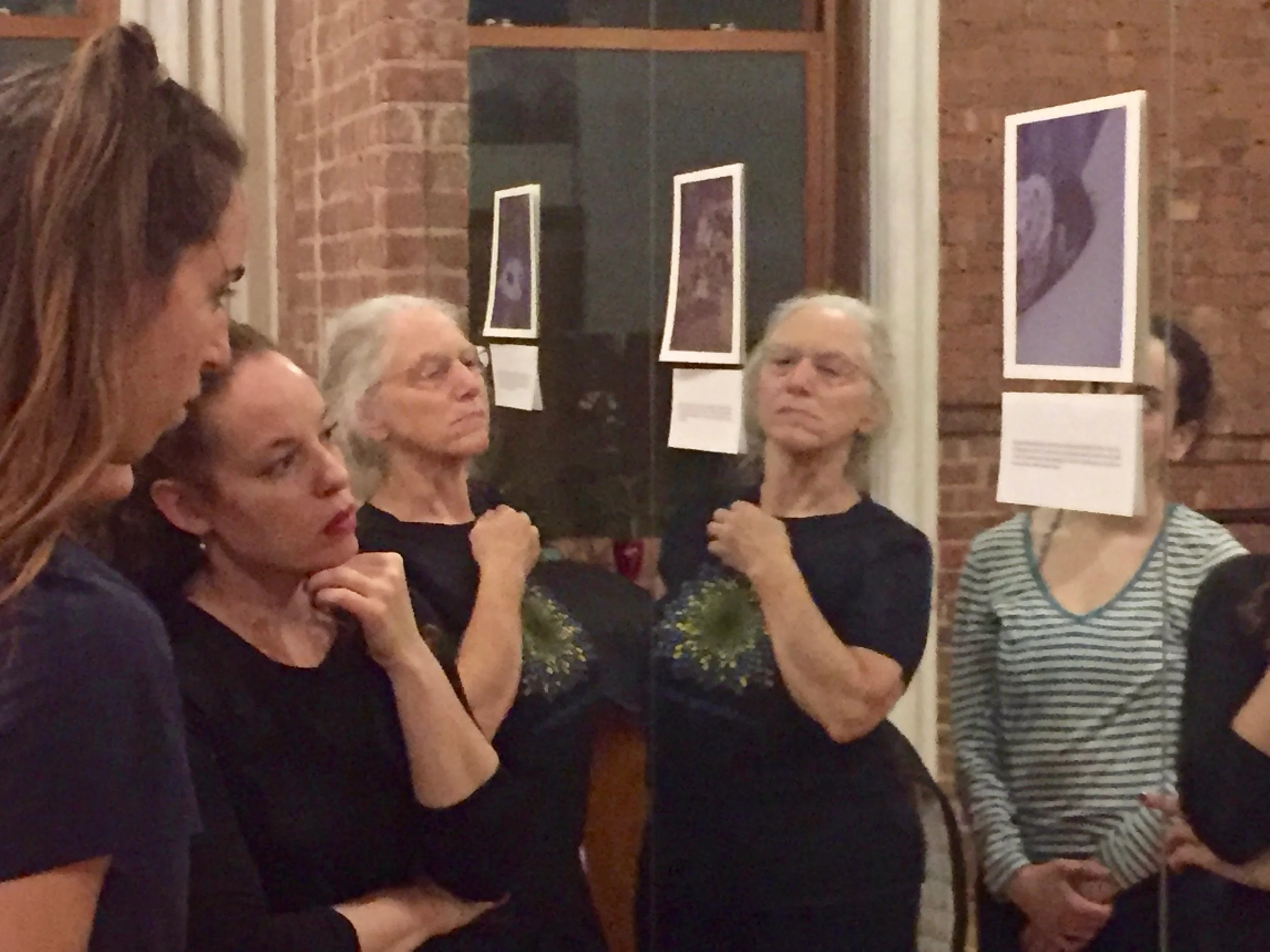 Close up of mall three dancers in rehearsal looking at an image posted on the mirror.